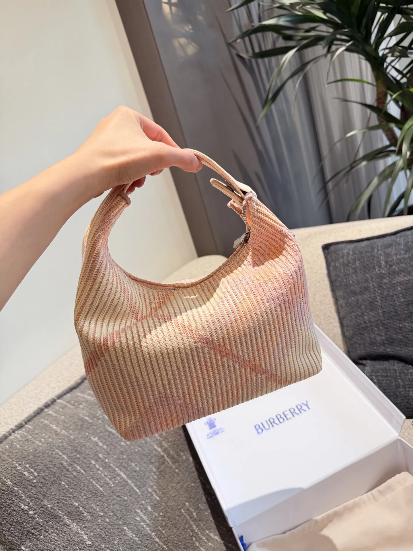 p215 Burberry粉色Peg腋下包 Burberry粉色Peg腋下包,采用柔软编织材质,触感温暖轻盈,春夏穿搭超适合!包身简约,经典格纹+蜜桃粉,清新优雅又百搭+。23x10.5x21.5cm约23x10.5x21.5cm,容量适中,通勤休闲都能hold住。双提手设计,手提肩背都OK,实用又时髦。Peg系列是Burberry经典款,时尚圈超受欢迎,春夏裙装或休闲装都能轻松搭配,日常出街必备!