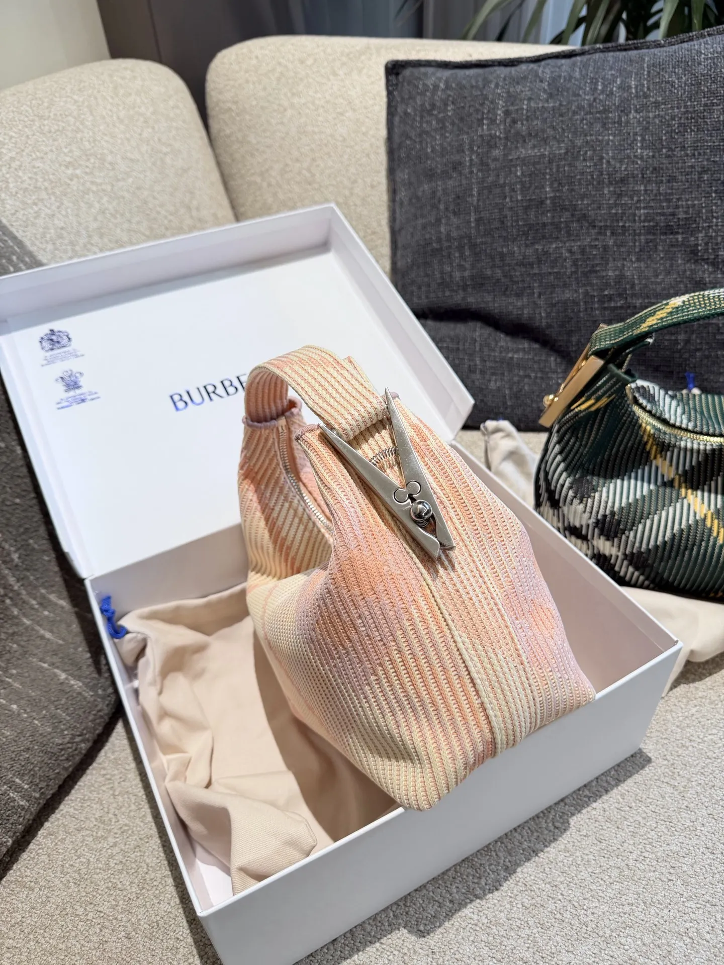 p215 Burberry粉色Peg腋下包 Burberry粉色Peg腋下包,采用柔软编织材质,触感温暖轻盈,春夏穿搭超适合!包身简约,经典格纹+蜜桃粉,清新优雅又百搭+。23x10.5x21.5cm约23x10.5x21.5cm,容量适中,通勤休闲都能hold住。双提手设计,手提肩背都OK,实用又时髦。Peg系列是Burberry经典款,时尚圈超受欢迎,春夏裙装或休闲装都能轻松搭配,日常出街必备!