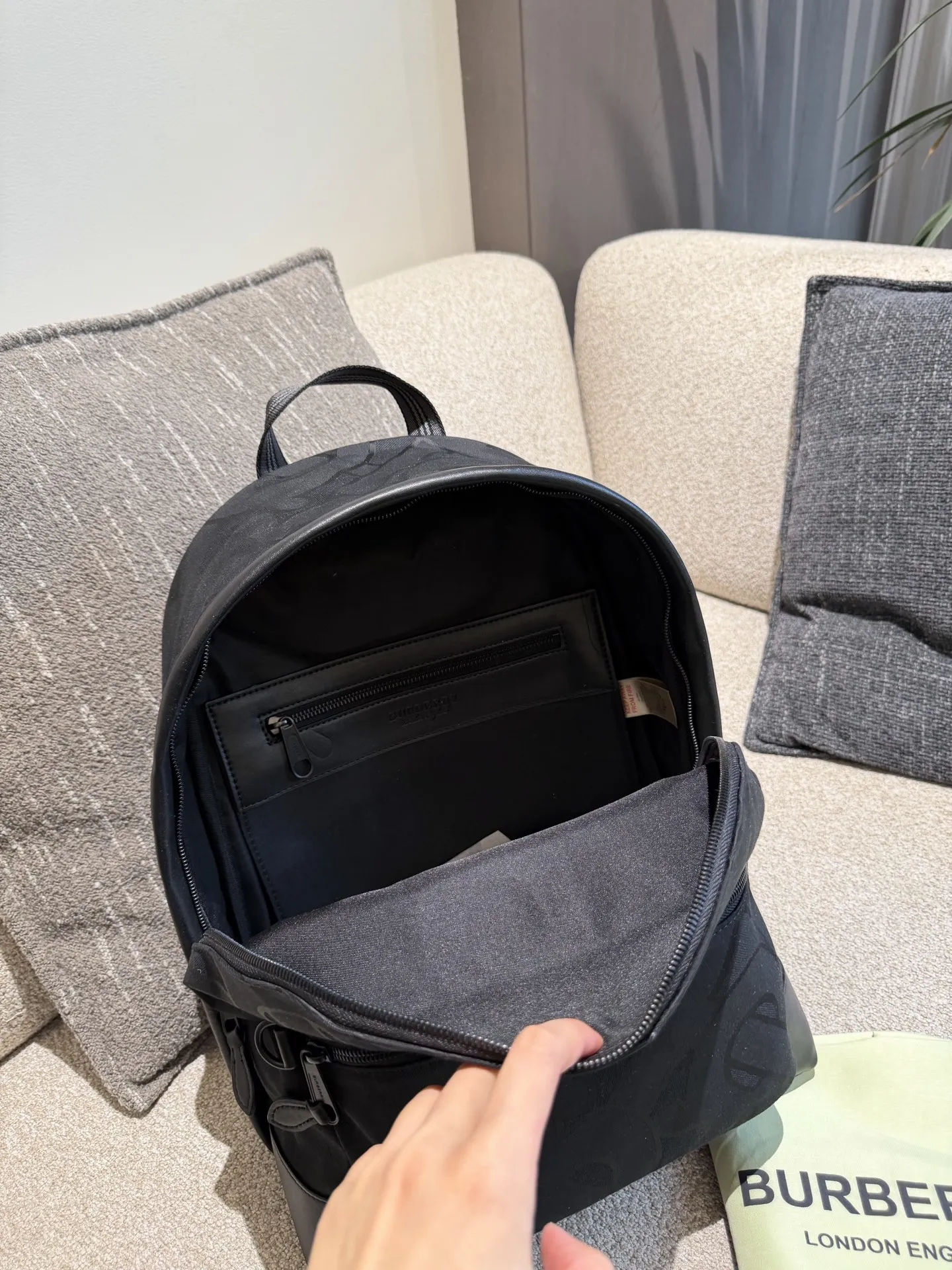 p220 Burberry TB标识尼龙双肩包 Burberry TB标识尼龙双肩包，黑色尼龙材质+经典TB提花，低调又有辨识度+。包身自重轻，容量大，通勤、短途旅行都超实用!内部隔层丰富，能装下电脑、文件等日常物品，外部拉链口袋方便收纳小物。尼龙材质耐用易清洁，还很环保。男女都能背，简约百搭，实用又时髦，是出行必备好物!32&times;40