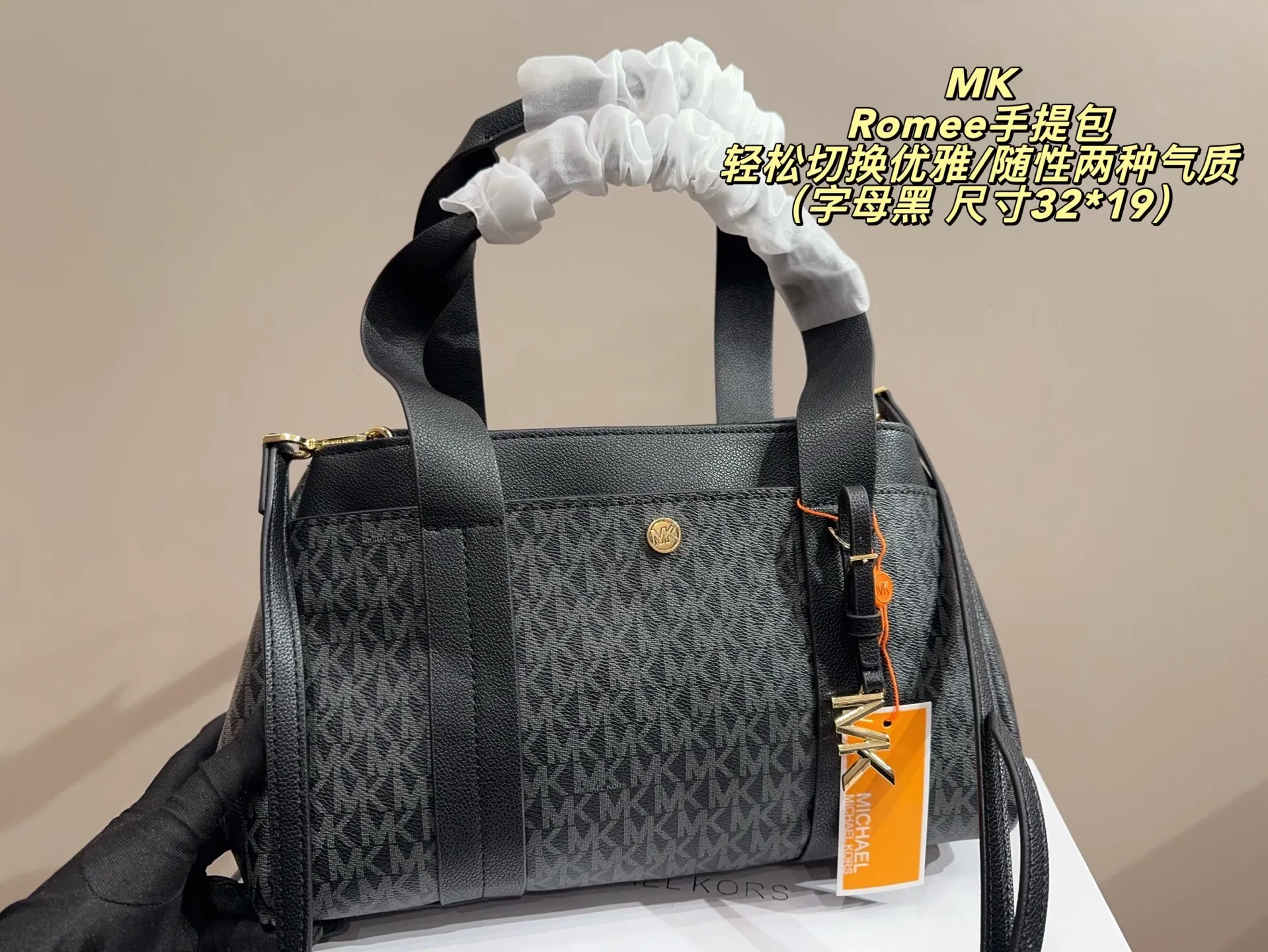 P165配盒⚠️尺寸32*19 MK Romee手提包 老花面料是MK标志性元素,皮质拼接提升质感,背出门自带“低调轻奢”的辨识度。 包身自带外侧小口袋+内侧隔层,既保证了“精致小包”的外观,又能有序收纳手机、口红等随身物,实用与高级感兼顾