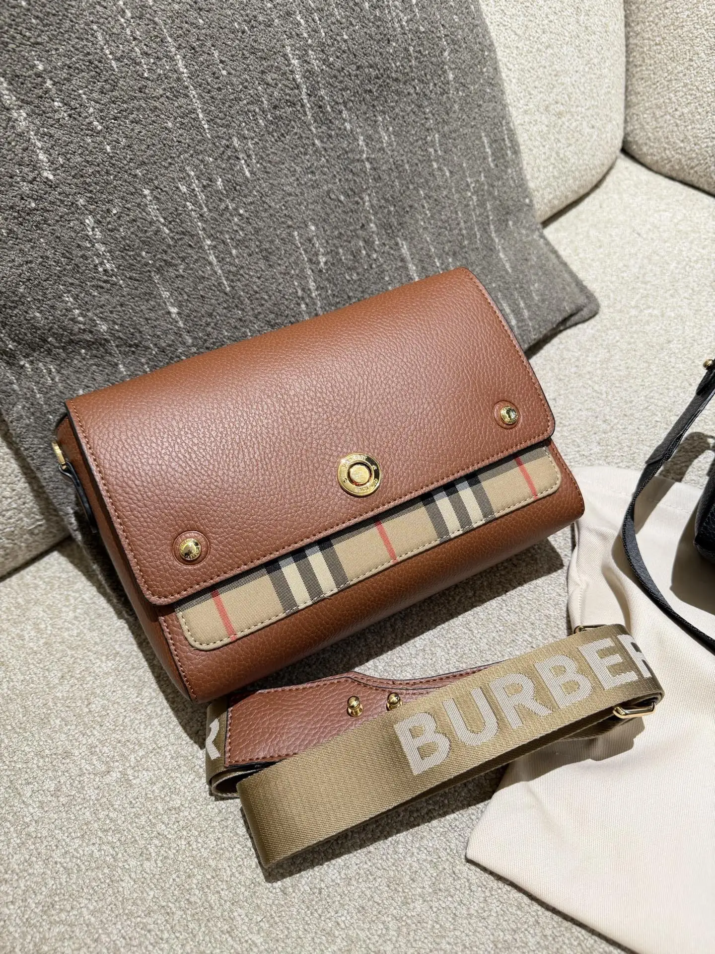 Burberry Note邮差包p165 Burberry Note邮差包,荔枝纹牛皮+经典格纹拼接,低 调又高级!25x17x8cm25x17x8cm,容量超能装,iPad、 雨伞都能放,通勤日常都OK++。宽肩带可调节,减压又百搭,休闲西装都能配。包盖吸扣设计,开合方便,内部空间合理,实用性满分!荔枝纹耐磨耐用,日常通勤、旅行都很 适合,是Burberry经典款,真的很推荐入手!