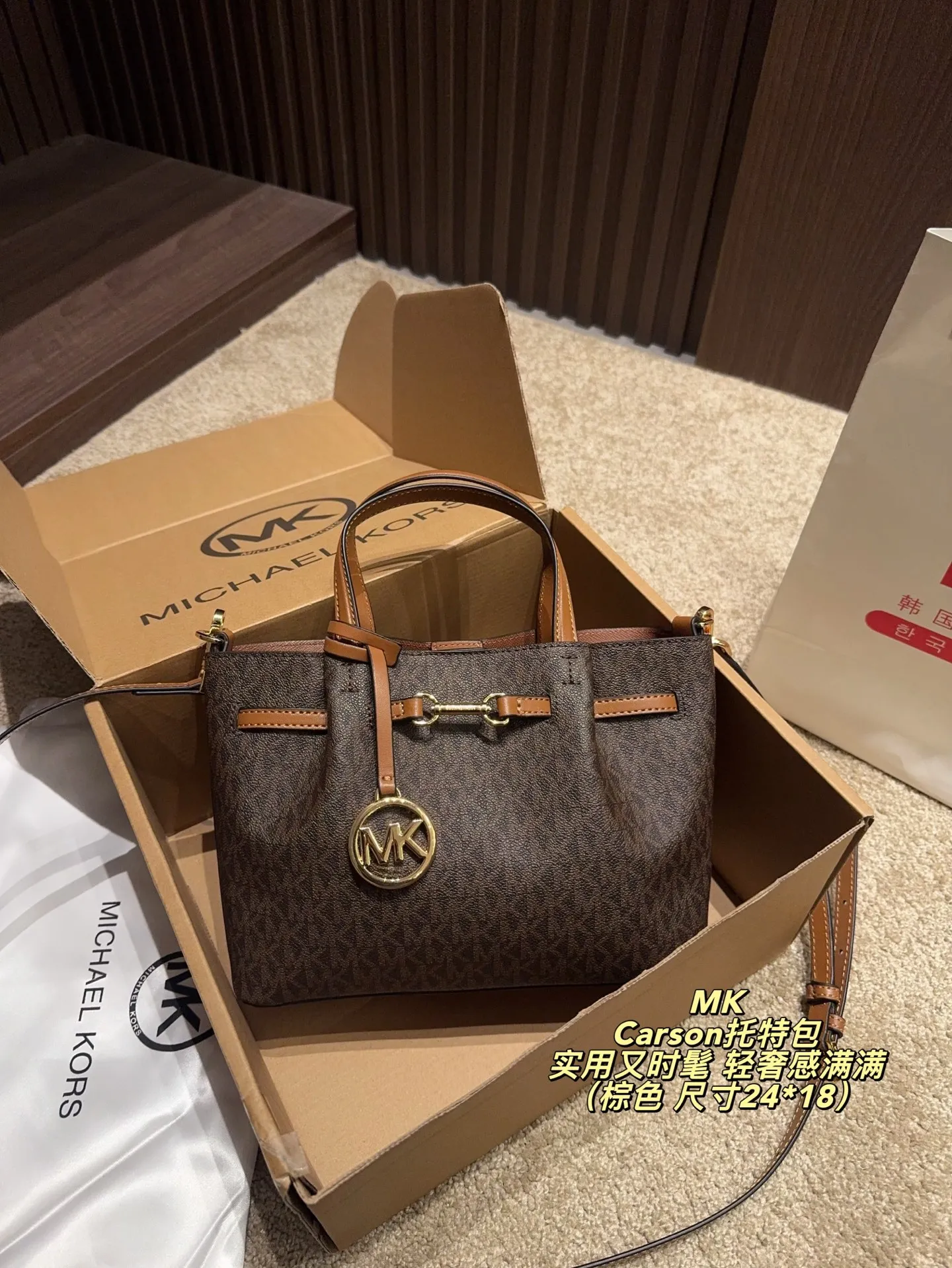 P170配飞机盒⚠️尺寸24*18 MK Carson系列马街扣托特包 经典老花PVC材质+棕色皮革饰边，简约大气又耐用。标志性马街扣＋圆形MK吊牌，辦识度超高！通勤日常都OK，手提斜挎随心切换。内部空问超能装，雨伞、水杯、化妆品统搞定，实用又时髦，轻奢感满满，是MK家超火的百搭款！