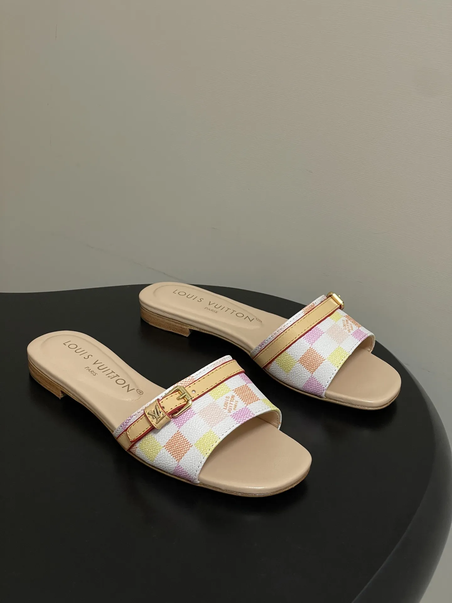 p260- 25ss夏季新款 LOUIS VUITTON 路易威登 Lv L经典棋盘格平底一字带凉拖鞋 采用经典的棋盘格图案设计,由粉色、黄色、白色等多种柔和色调组成,色彩搭配清新且富有层次感,视觉上给人活泼俏皮的感觉。同时,棋盘格作为LV的标志性元素之一,彰显品牌独特风格与辨识度。 鞋面上有一条皮质鞋带,增加了鞋子的层次感和可调节性。鞋带两端配有金属扣装饰,精致的金属配件不仅提升了鞋子的质感,还为整体造型增添了一丝时尚感和精致感。 鞋面:定制老花皮 内里垫脚:羊皮 鞋底:意大利加厚真皮大底 码数:35-41(40.41定做不退换)