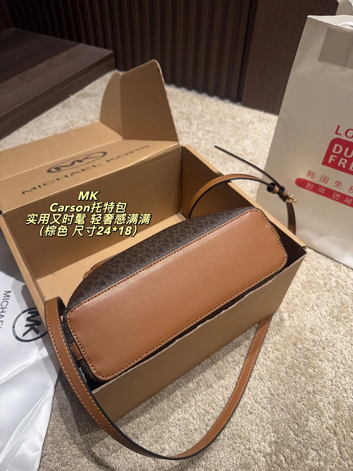 P170配飞机盒⚠️尺寸24*18 MK Carson系列马街扣托特包 经典老花PVC材质+棕色皮革饰边，简约大气又耐用。标志性马街扣＋圆形MK吊牌，辦识度超高！通勤日常都OK，手提斜挎随心切换。内部空问超能装，雨伞、水杯、化妆品统搞定，实用又时髦，轻奢感满满，是MK家超火的百搭款！