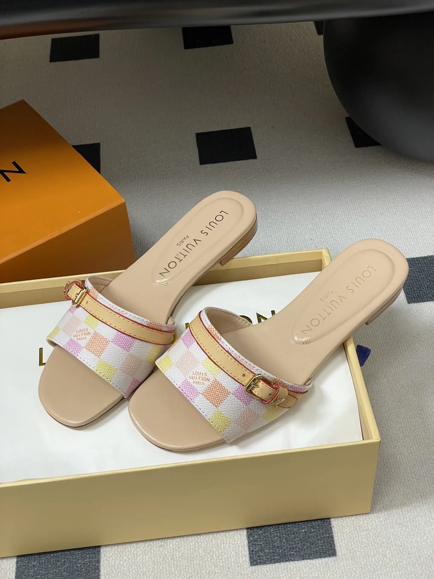 p260- 25ss夏季新款 LOUIS VUITTON 路易威登 Lv L经典棋盘格平底一字带凉拖鞋 采用经典的棋盘格图案设计,由粉色、黄色、白色等多种柔和色调组成,色彩搭配清新且富有层次感,视觉上给人活泼俏皮的感觉。同时,棋盘格作为LV的标志性元素之一,彰显品牌独特风格与辨识度。 鞋面上有一条皮质鞋带,增加了鞋子的层次感和可调节性。鞋带两端配有金属扣装饰,精致的金属配件不仅提升了鞋子的质感,还为整体造型增添了一丝时尚感和精致感。 鞋面:定制老花皮 内里垫脚:羊皮 鞋底:意大利加厚真皮大底 码数:35-41(40.41定做不退换)