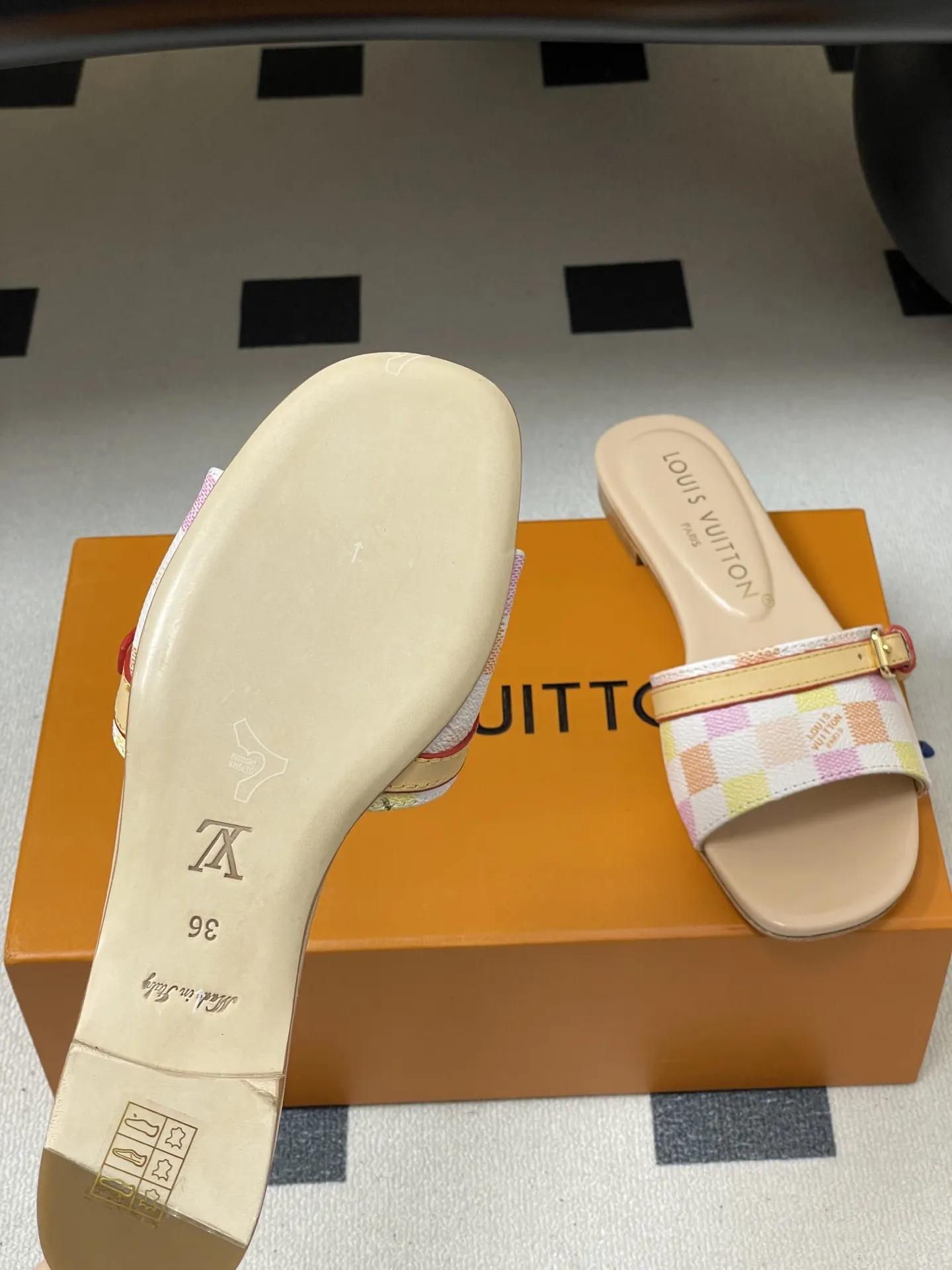 p260- 25ss夏季新款 LOUIS VUITTON 路易威登 Lv L经典棋盘格平底一字带凉拖鞋 采用经典的棋盘格图案设计,由粉色、黄色、白色等多种柔和色调组成,色彩搭配清新且富有层次感,视觉上给人活泼俏皮的感觉。同时,棋盘格作为LV的标志性元素之一,彰显品牌独特风格与辨识度。 鞋面上有一条皮质鞋带,增加了鞋子的层次感和可调节性。鞋带两端配有金属扣装饰,精致的金属配件不仅提升了鞋子的质感,还为整体造型增添了一丝时尚感和精致感。 鞋面:定制老花皮 内里垫脚:羊皮 鞋底:意大利加厚真皮大底 码数:35-41(40.41定做不退换)