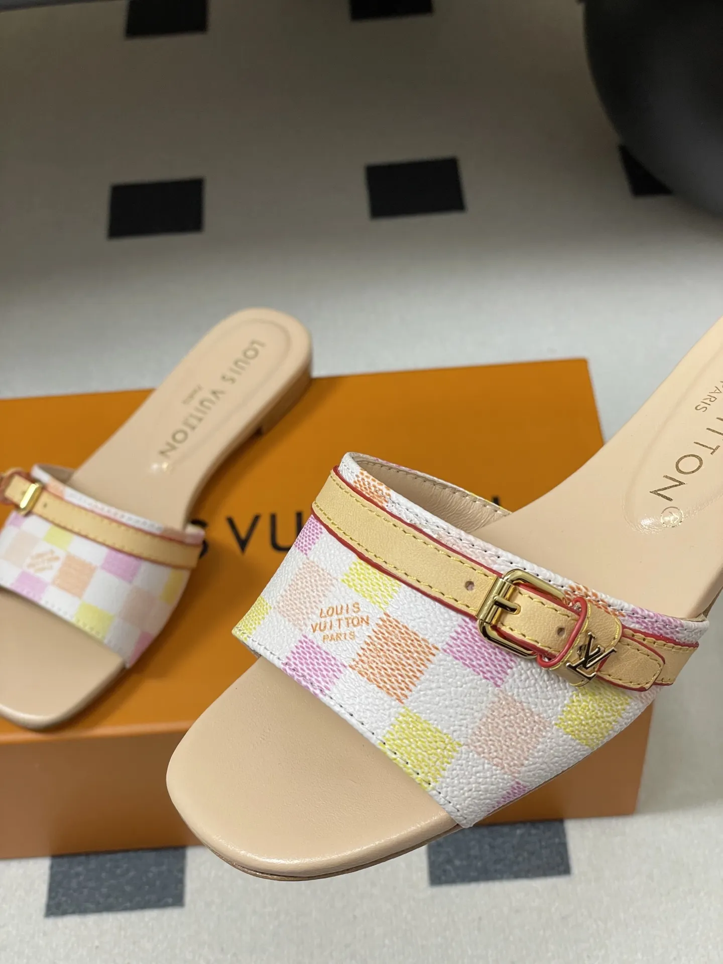 p260- 25ss夏季新款 LOUIS VUITTON 路易威登 Lv L经典棋盘格平底一字带凉拖鞋 采用经典的棋盘格图案设计,由粉色、黄色、白色等多种柔和色调组成,色彩搭配清新且富有层次感,视觉上给人活泼俏皮的感觉。同时,棋盘格作为LV的标志性元素之一,彰显品牌独特风格与辨识度。 鞋面上有一条皮质鞋带,增加了鞋子的层次感和可调节性。鞋带两端配有金属扣装饰,精致的金属配件不仅提升了鞋子的质感,还为整体造型增添了一丝时尚感和精致感。 鞋面:定制老花皮 内里垫脚:羊皮 鞋底:意大利加厚真皮大底 码数:35-41(40.41定做不退换)