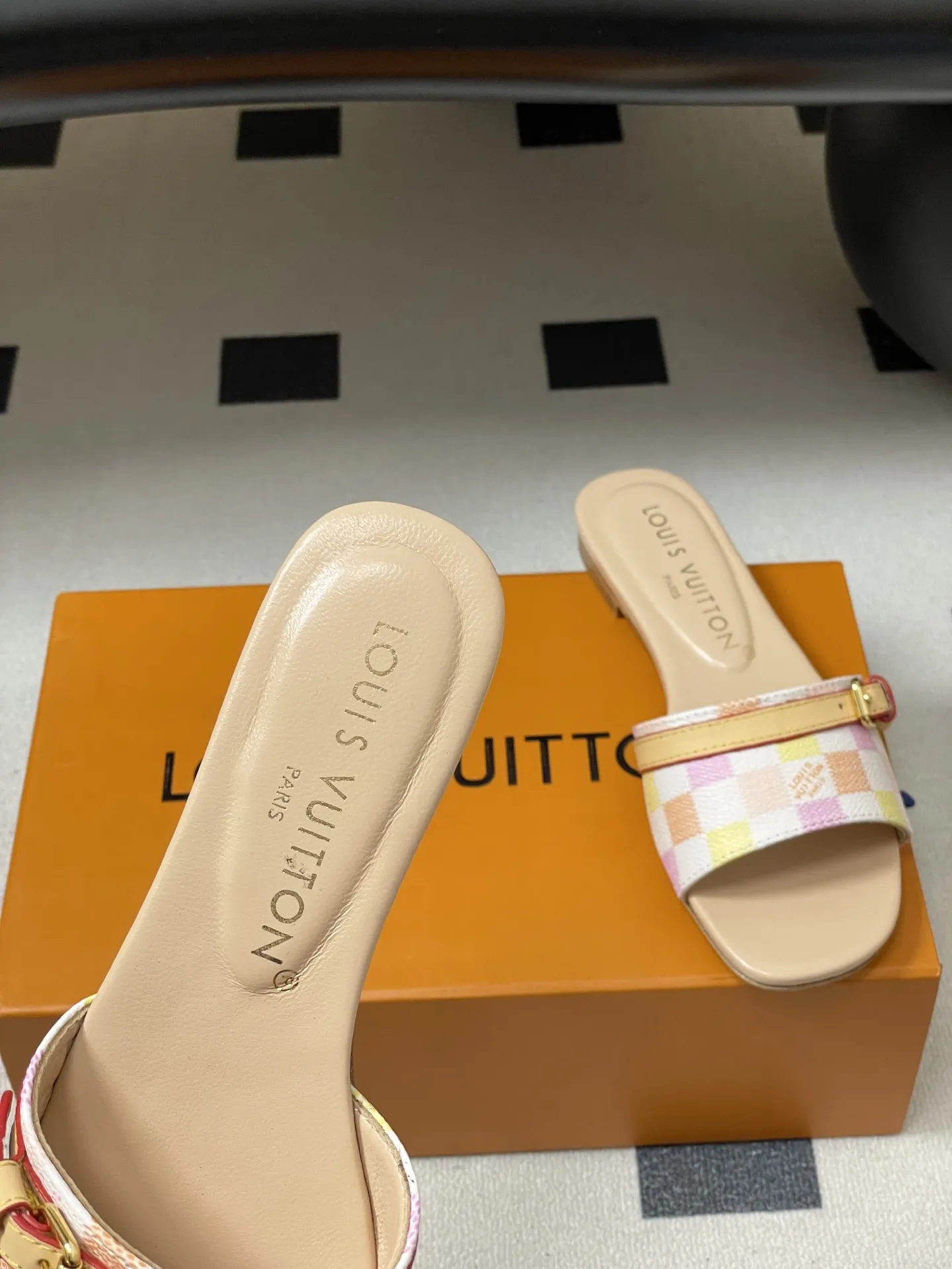 p260- 25ss夏季新款 LOUIS VUITTON 路易威登 Lv L经典棋盘格平底一字带凉拖鞋 采用经典的棋盘格图案设计,由粉色、黄色、白色等多种柔和色调组成,色彩搭配清新且富有层次感,视觉上给人活泼俏皮的感觉。同时,棋盘格作为LV的标志性元素之一,彰显品牌独特风格与辨识度。 鞋面上有一条皮质鞋带,增加了鞋子的层次感和可调节性。鞋带两端配有金属扣装饰,精致的金属配件不仅提升了鞋子的质感,还为整体造型增添了一丝时尚感和精致感。 鞋面:定制老花皮 内里垫脚:羊皮 鞋底:意大利加厚真皮大底 码数:35-41(40.41定做不退换)
