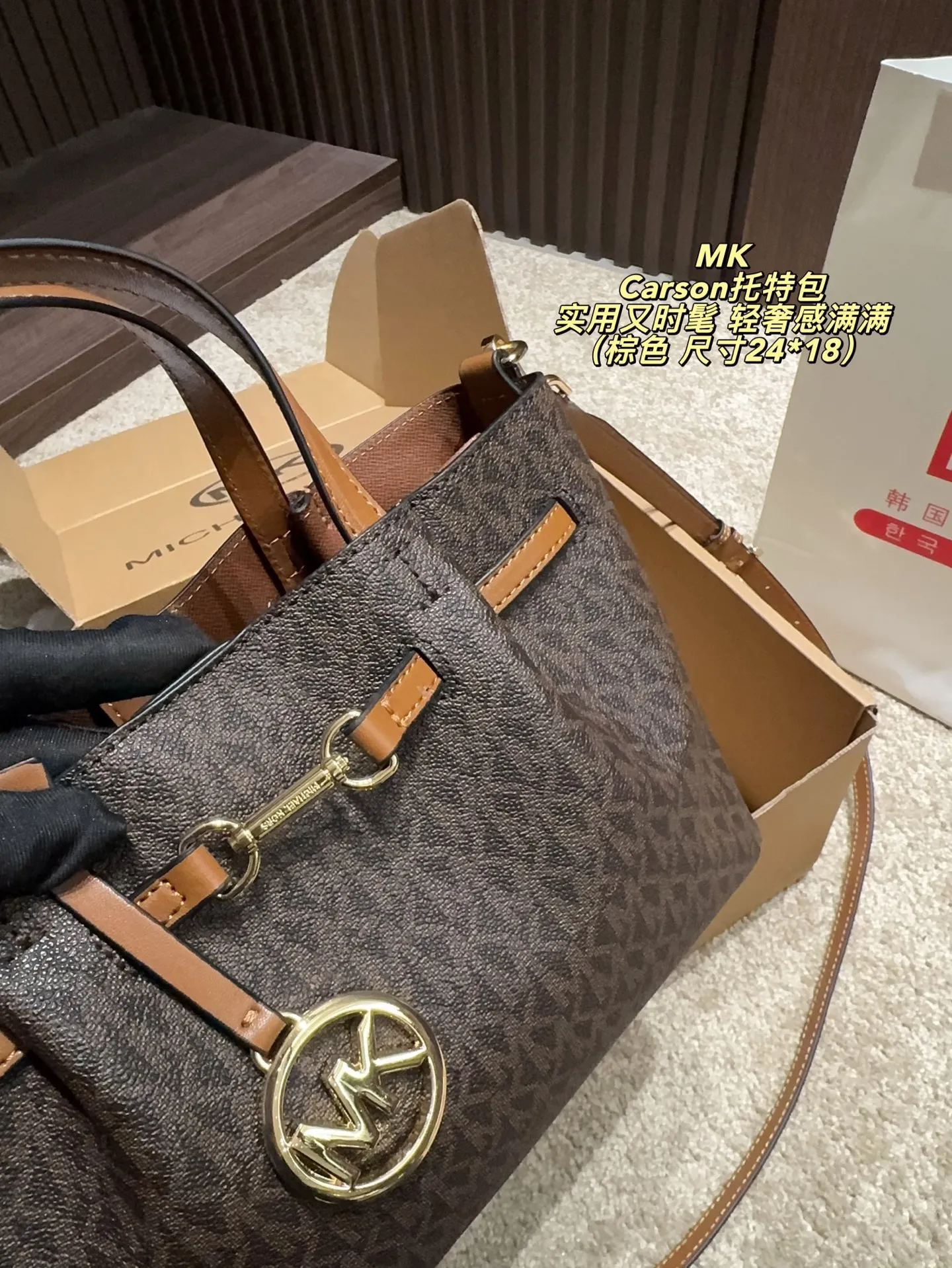 P170配飞机盒⚠️尺寸24*18 MK Carson系列马街扣托特包 经典老花PVC材质+棕色皮革饰边，简约大气又耐用。标志性马街扣＋圆形MK吊牌，辦识度超高！通勤日常都OK，手提斜挎随心切换。内部空问超能装，雨伞、水杯、化妆品统搞定，实用又时髦，轻奢感满满，是MK家超火的百搭款！