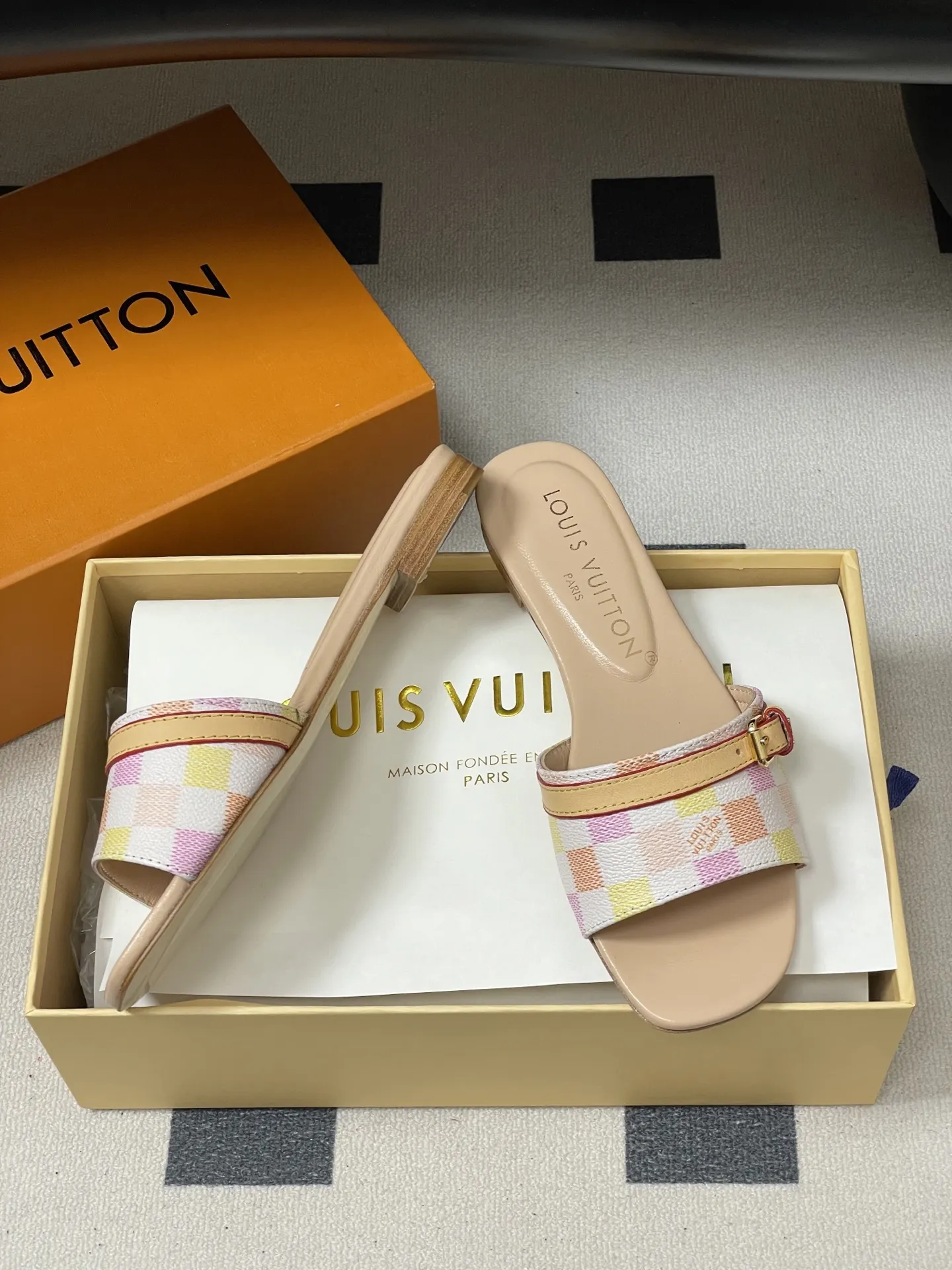 p260- 25ss夏季新款 LOUIS VUITTON 路易威登 Lv L经典棋盘格平底一字带凉拖鞋 采用经典的棋盘格图案设计,由粉色、黄色、白色等多种柔和色调组成,色彩搭配清新且富有层次感,视觉上给人活泼俏皮的感觉。同时,棋盘格作为LV的标志性元素之一,彰显品牌独特风格与辨识度。 鞋面上有一条皮质鞋带,增加了鞋子的层次感和可调节性。鞋带两端配有金属扣装饰,精致的金属配件不仅提升了鞋子的质感,还为整体造型增添了一丝时尚感和精致感。 鞋面:定制老花皮 内里垫脚:羊皮 鞋底:意大利加厚真皮大底 码数:35-41(40.41定做不退换)