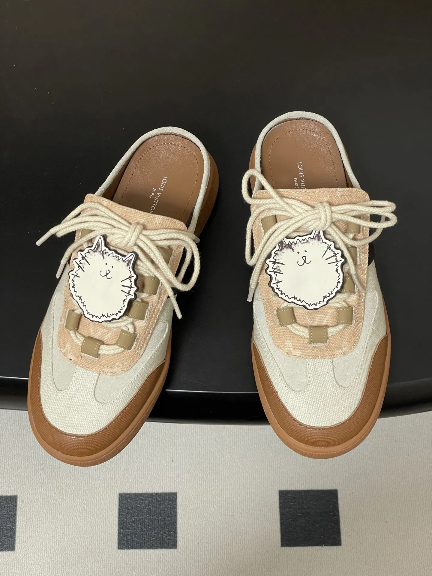 p310-(配高档飞机盒✈️) 2026春夏新款 LOUIS VUITTON 路易威登 LV Grace Coddington / 联名款猫猫Catogram系列 Lous露跟运动鞋系带包头穆勒厚底半拖鞋 LV与Grace Coddington联名的猫猫系列半拖鞋,米白+棕色拼接,麂皮和织物材质,鞋面有猫咪挂饰超可爱! 本款Lous露跟运动鞋携Monogram压纹绒面牛皮革重回视野,为加垫鞋舌压印路易威登标识,与双鞋带一道展露滑板鞋的灵感启发。便 捷穿脱的设计升级舒适体验。 鞋面:定制布料拼接牛反绒 内里垫脚:羊皮 鞋底:开模橡胶大底 码数:女35-39(40.41定做不退换)