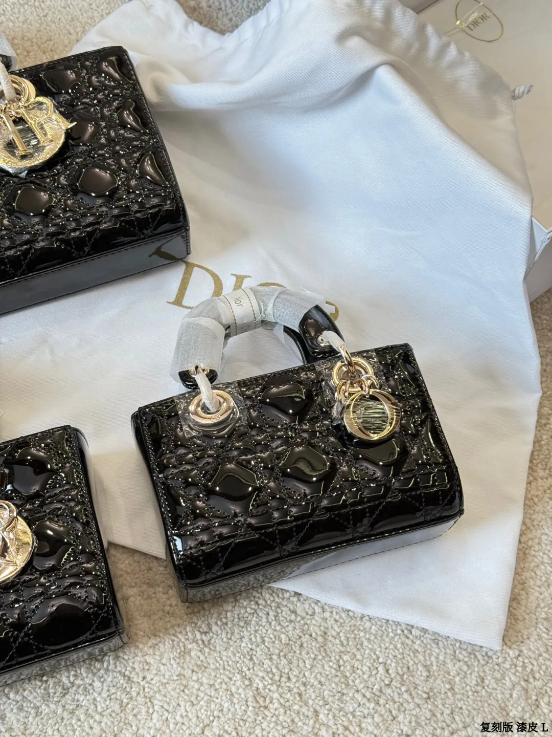 复刻版 漆皮 p205/p200/p195 Dior D-Joy 漆皮横版戴妃包 Dior D-Joy漆皮横版戴妃包，黑色漆皮+藤格纹绗缝，浅金色D.1.0.R吊饰超有辨识度。横版设计，26x13.5x5cm约26x13.5x5cm，配可拆卸链条肩带和皮革肩带，手提、肩背、斜挎都OK！漆皮耐磨易清洁，日常通勤或正式场合都能轻松驾驭，优雅又实用，是Dior经典系列的时髦代表 26x13.5x5cm 26cm 23cm 17cm