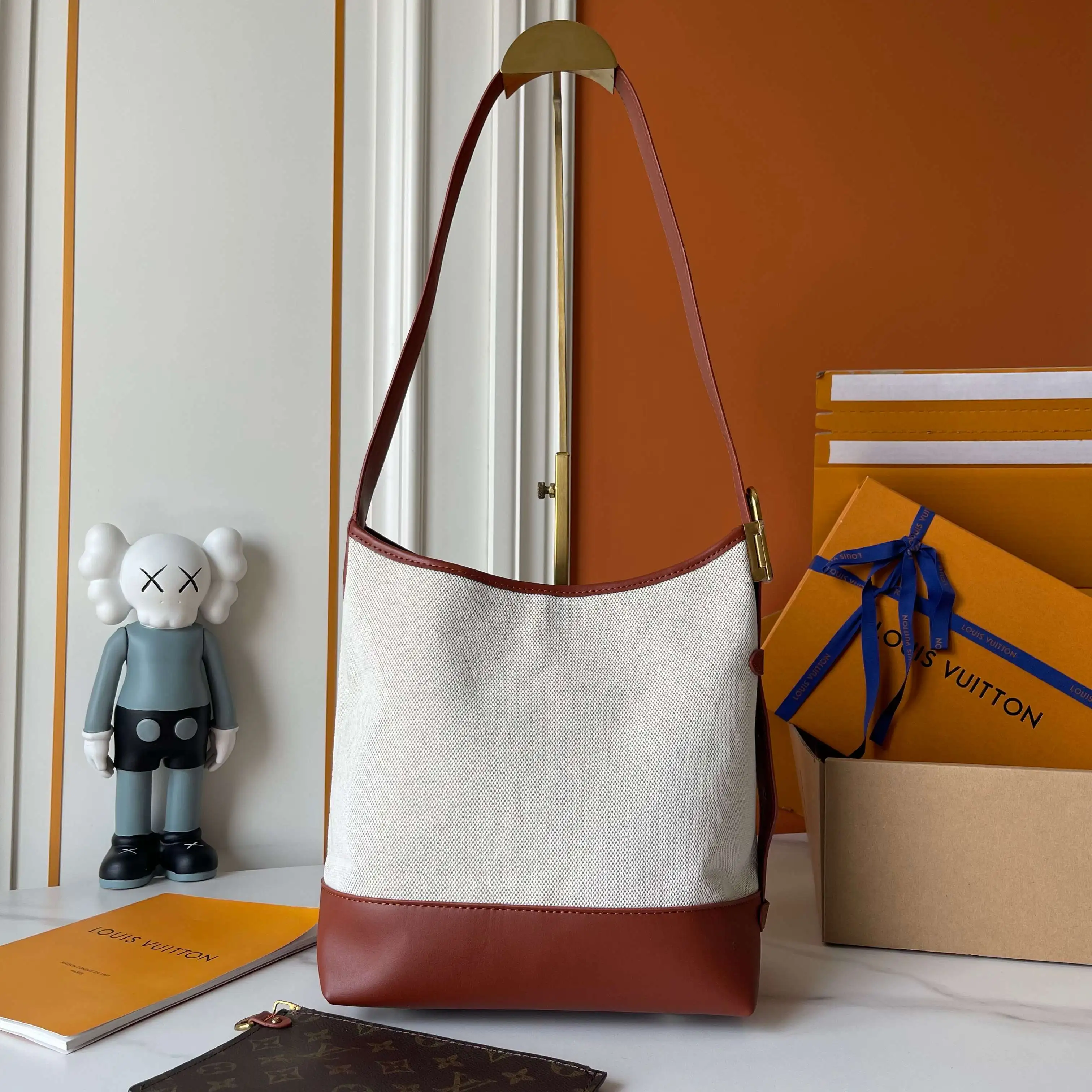 升级版批 160 M25468米白帆布 M44022棕色皮水桶包 当季新款 LOW KEY HOBO 小号手袋 本款 Low Key Hobo 小号手袋糅合帆布和牛皮革，以肌理反差演绎新季优雅格调。做旧金属件和可拆卸 Monogram 拉链内袋回溯品牌制箱传承，条纹内衬彰显考究细节。28 x 16 x 24 厘米。