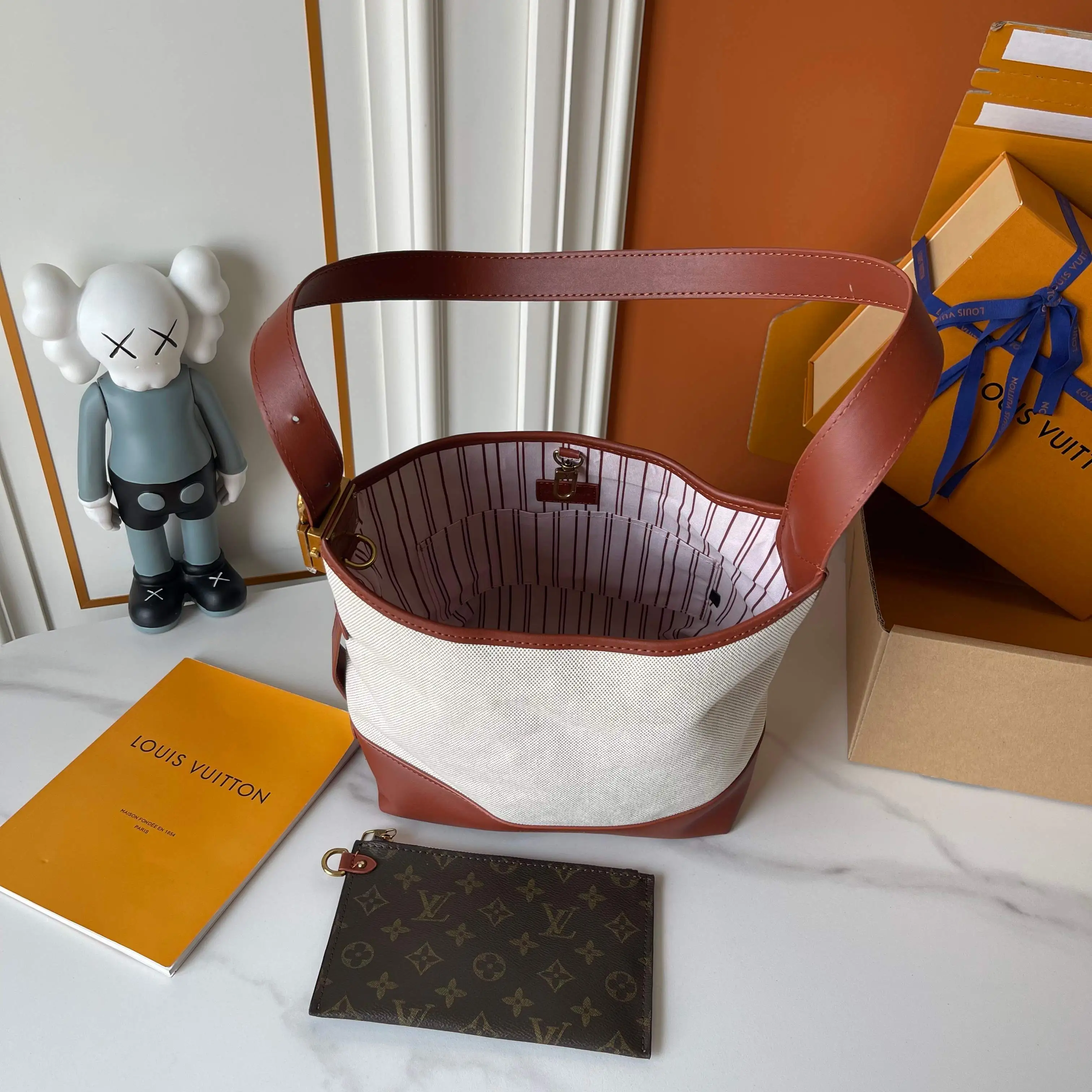 升级版批 160 M25468米白帆布 M44022棕色皮水桶包 当季新款 LOW KEY HOBO 小号手袋 本款 Low Key Hobo 小号手袋糅合帆布和牛皮革,以肌理反差演绎新季优雅格调。做旧金属件和可拆卸 Monogram 拉链内袋回溯品牌制箱传承,条纹内衬彰显考究细节。28 x 16 x 24 厘米。