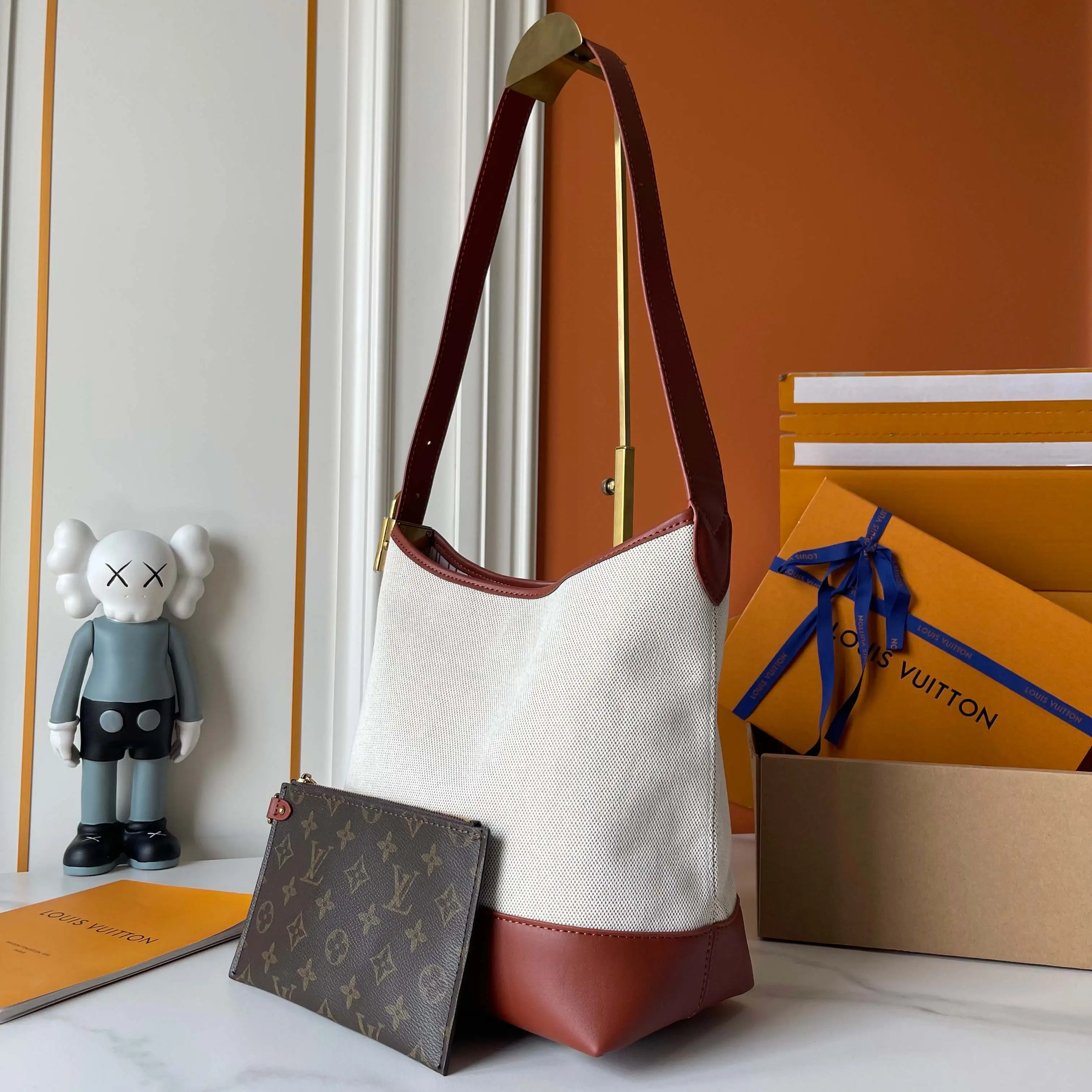 升级版批 160 M25468米白帆布 M44022棕色皮水桶包 当季新款 LOW KEY HOBO 小号手袋 本款 Low Key Hobo 小号手袋糅合帆布和牛皮革，以肌理反差演绎新季优雅格调。做旧金属件和可拆卸 Monogram 拉链内袋回溯品牌制箱传承，条纹内衬彰显考究细节。28 x 16 x 24 厘米。