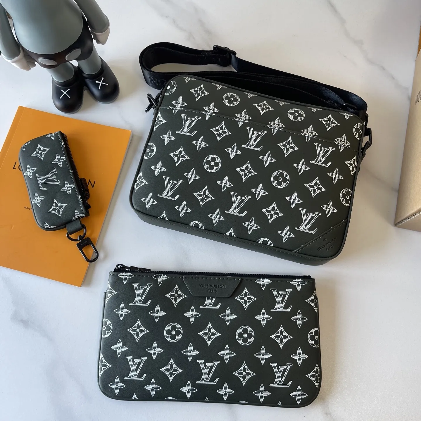 升级版批 170 M26713 M27185 M27925 M27154（拍摄灯光下存在视觉色差）M46602 M45320 M69443 条纹压花【 Trio Messenger邮差包】取材柔软 Monogram Shadow牛皮革，搭配Monogram Shadow 皮革袢带与主袋。拉链前袋、肩带与点缀其上的零钱包均可拆卸。肩带亦可调节，确保背携舒适贴合。 尺寸:18.5x7x25 厘米