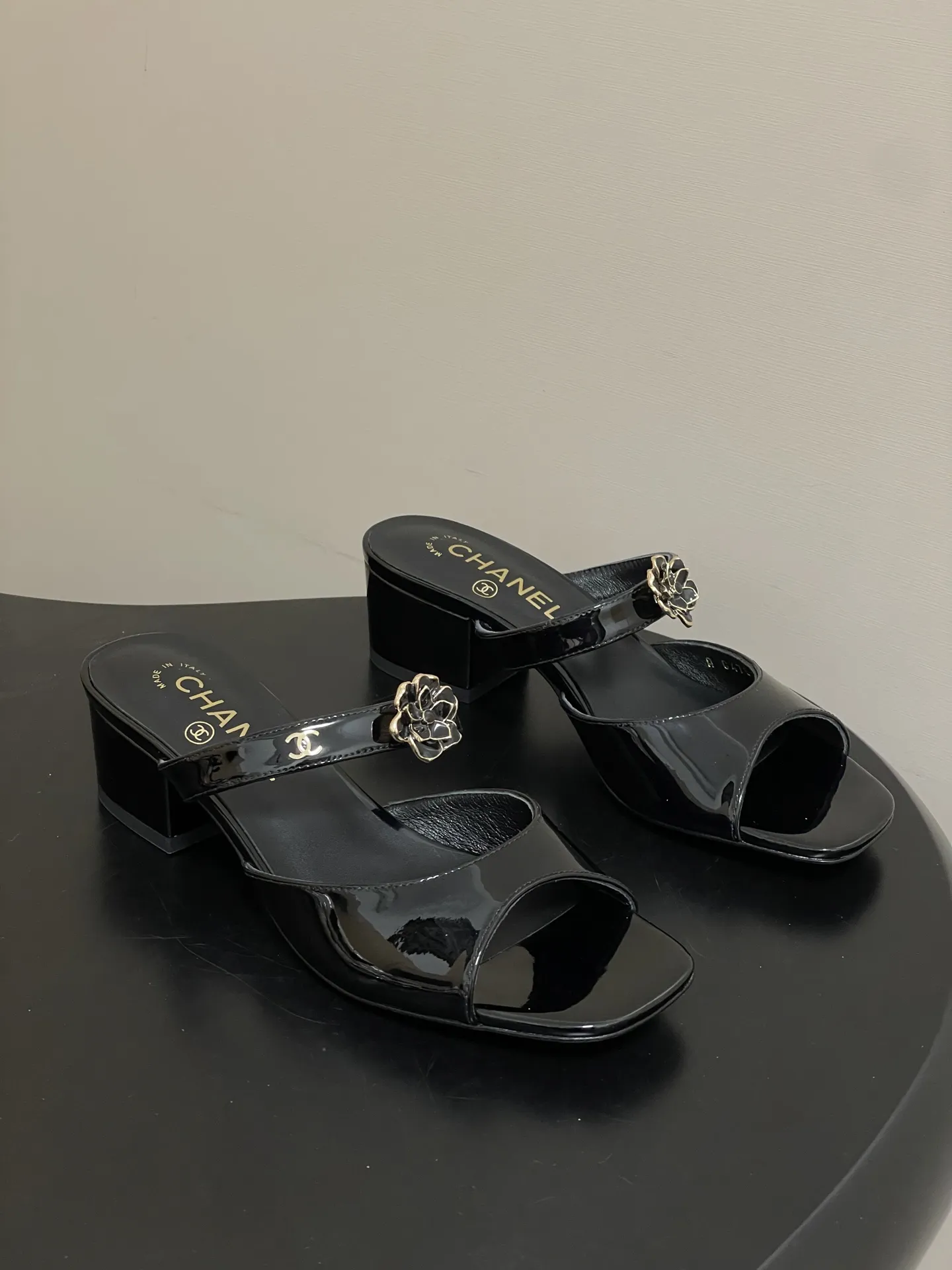 p250- 26Ss春夏新款Chanel 小香26最新走秀款 经典双C扣山茶花一字拖鞋高跟凉拖鞋方头鱼嘴双带粗跟凉拖鞋 C家经典山茶花设计，温柔风一整个拿捏了！夏天该有的气息 一字拖必备单品，上脚慵懒舒适！ 每一片花瓣都是皮革手工制作，对于材质毫不含糊，非常注重质感细节的一款。 鞋面：牛漆皮 内里垫脚：羊皮 跟高：7.5cm/4.5cm 鞋底：意大利真皮大底 码数：35-39（40.41定做不退换）