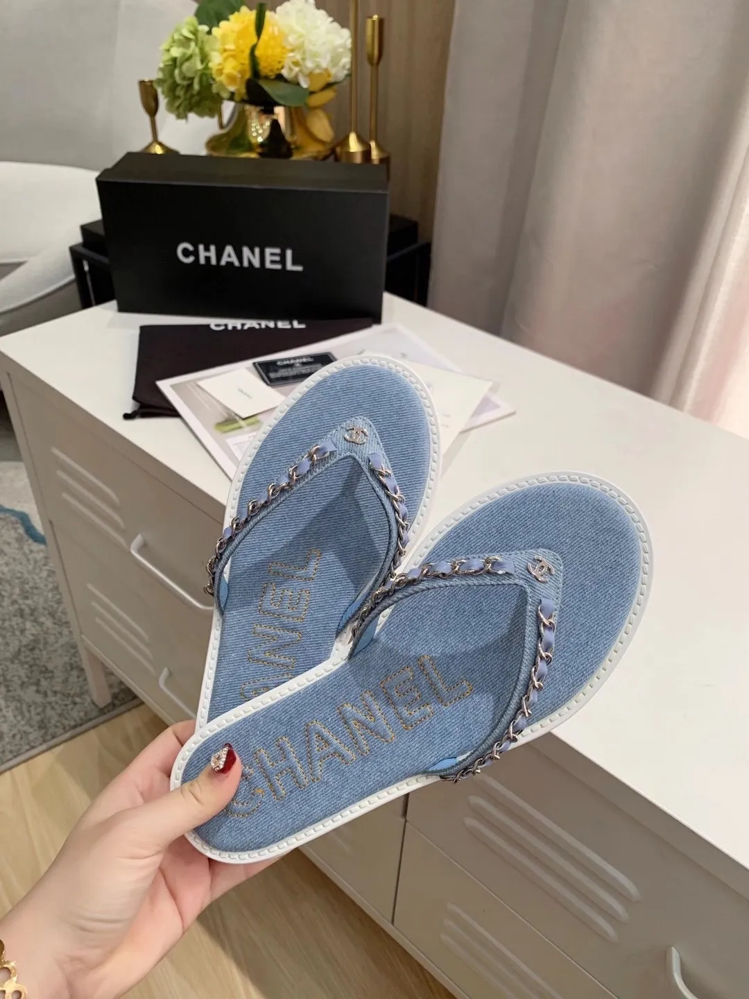 出厂价：130元 Chanel 春季新款 牛仔 链条人字拖鞋✅ 首发这个鞋我真心的心动💓 第一眼[惊讶]看到就喜欢，颜色清晰又仙气😊 而且有Chanel 家的经典元素链条搭配独家 进口牛皮🐂 颜色：牛仔蓝、深蓝 码数：35&mdash;40 （41可定做不退换） 大底：橡胶大底（防滑耐磨） 包装：配卡片、布袋、小票。
