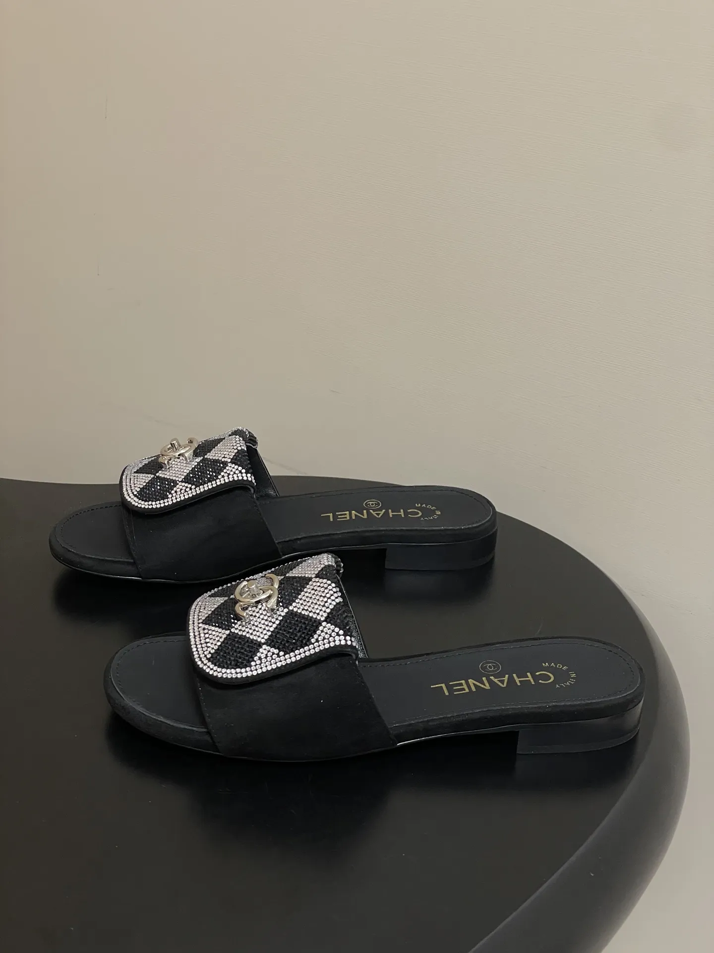 p240- 26Fw春夏新款Chanel小香经典翻盖书包扣水钻一字拖鞋新颖烫钻棋盘格粗跟拖鞋 经典永不过时 简约大气,标志性翻盖双C书包扣设计~手工镶嵌的水钻棋盘轮廓成星河,抬脚时折射出香槟色光晕,显瘦百搭~脚感非常舒适!凸显优雅的爆品 小香粉必入! 鞋面:羊猄皮/烫钻 内里垫脚:羊皮 高跟:平底/粗跟5cm 鞋底:意大利真皮大底 码数:35-39(40.41.42定做不退换)