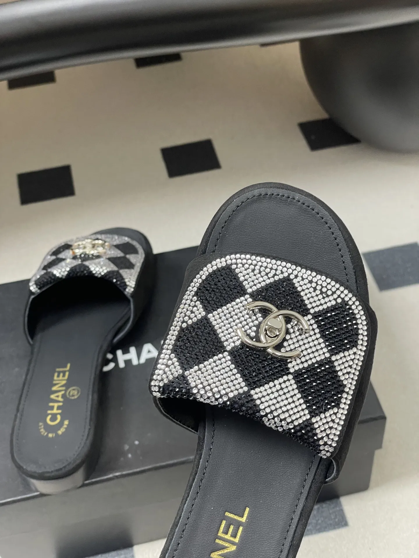 p240- 26Fw春夏新款Chanel小香经典翻盖书包扣水钻一字拖鞋新颖烫钻棋盘格粗跟拖鞋 经典永不过时 简约大气,标志性翻盖双C书包扣设计~手工镶嵌的水钻棋盘轮廓成星河,抬脚时折射出香槟色光晕,显瘦百搭~脚感非常舒适!凸显优雅的爆品 小香粉必入! 鞋面:羊猄皮/烫钻 内里垫脚:羊皮 高跟:平底/粗跟5cm 鞋底:意大利真皮大底 码数:35-39(40.41.42定做不退换)