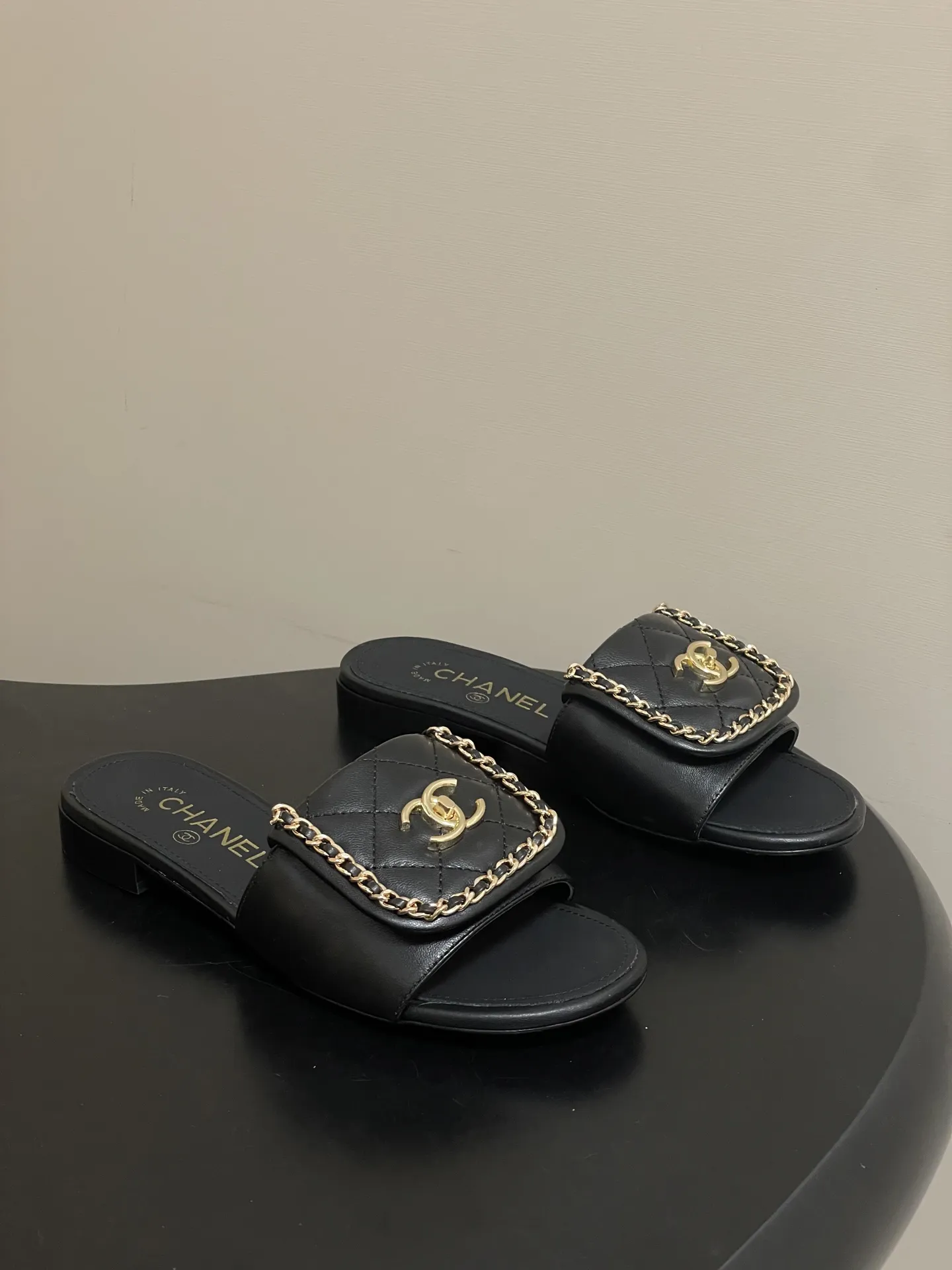 p240- 26Fw春夏新款Chanel小香经典翻盖书包扣链条一字拖鞋双C扣粗跟拖鞋 经典永不过时 简约大气,标志性翻盖双C书包扣配搭链条设计~显瘦百搭~脚感非常舒适!凸显优雅的爆品 小香粉必入! 鞋面:羊皮/定制链条 内里垫脚:羊皮 高跟:平底/粗跟5cm 鞋底:意大利真皮大底 码数:35-39(40.41.42定做不退换)