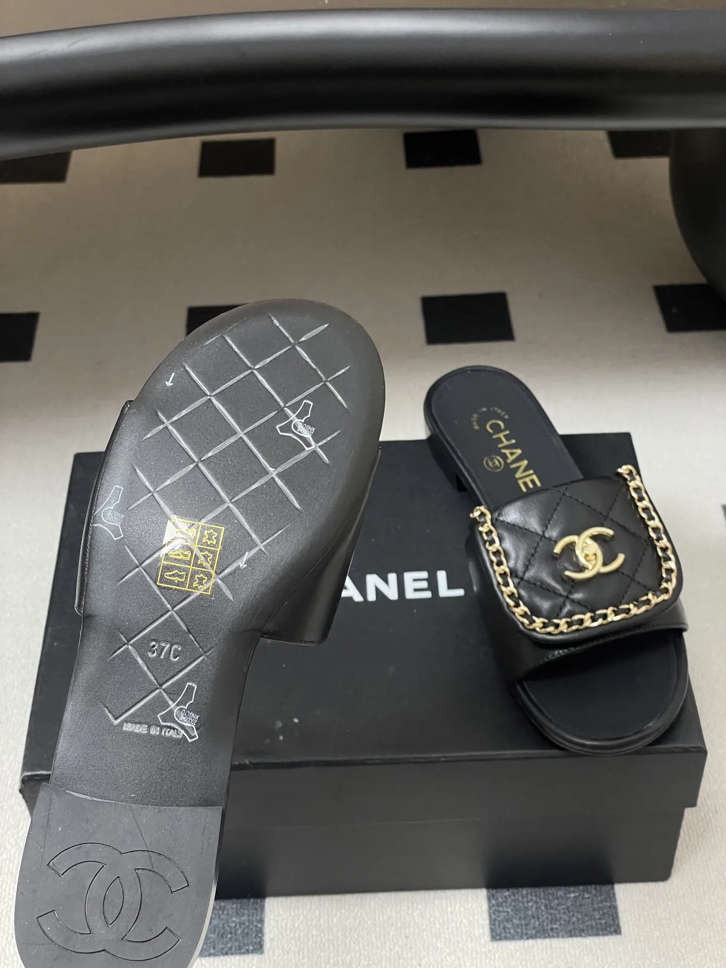 p240- 26Fw春夏新款Chanel小香经典翻盖书包扣链条一字拖鞋双C扣粗跟拖鞋 经典永不过时 简约大气，标志性翻盖双C书包扣配搭链条设计～显瘦百搭～脚感非常舒适！凸显优雅的爆品 小香粉必入！ 鞋面：羊皮/定制链条 内里垫脚：羊皮 高跟：平底/粗跟5cm 鞋底：意大利真皮大底 码数：35-39（40.41.42定做不退换）
