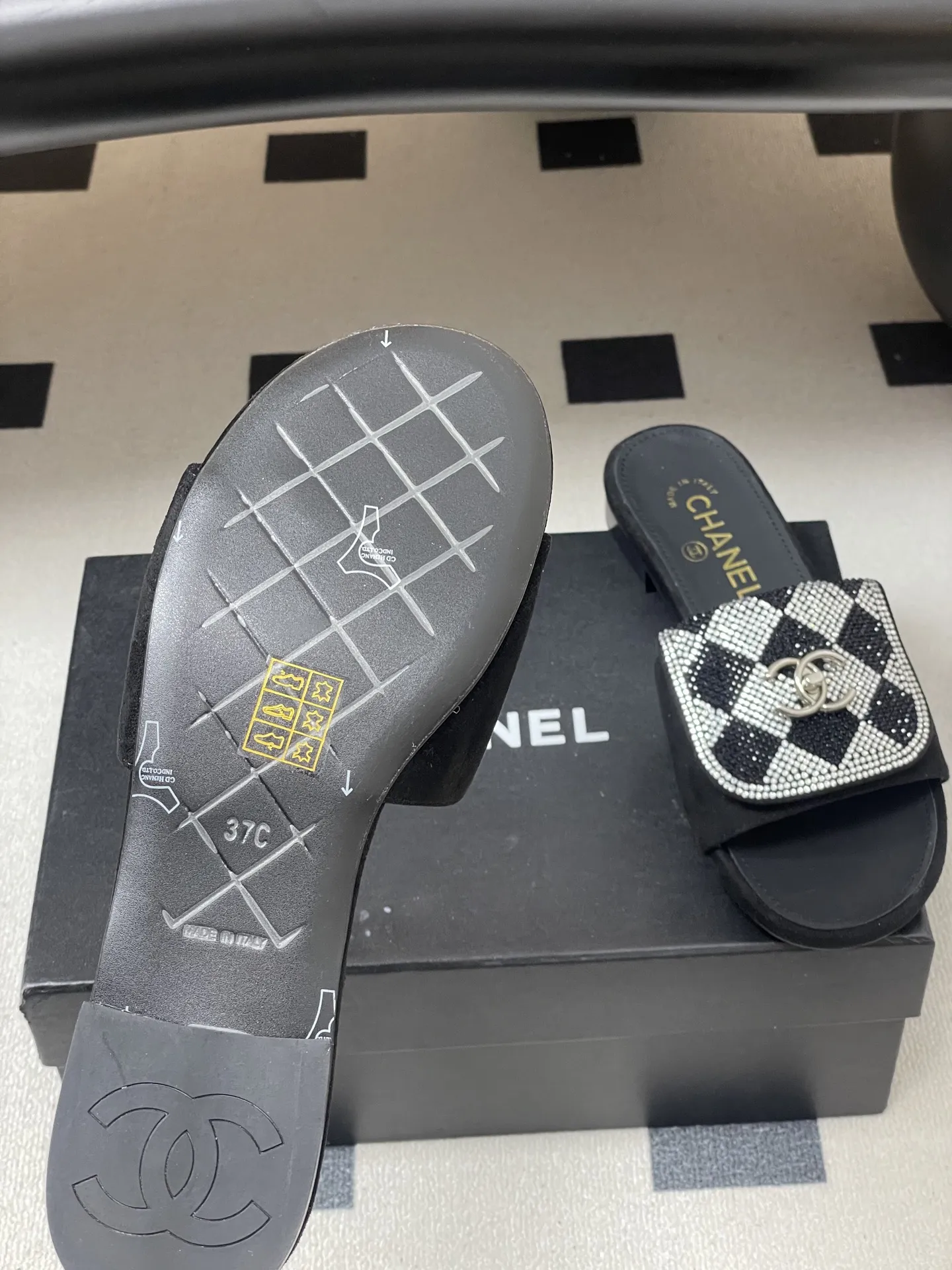 p240- 26Fw春夏新款Chanel小香经典翻盖书包扣水钻一字拖鞋新颖烫钻棋盘格粗跟拖鞋 经典永不过时 简约大气,标志性翻盖双C书包扣设计~手工镶嵌的水钻棋盘轮廓成星河,抬脚时折射出香槟色光晕,显瘦百搭~脚感非常舒适!凸显优雅的爆品 小香粉必入! 鞋面:羊猄皮/烫钻 内里垫脚:羊皮 高跟:平底/粗跟5cm 鞋底:意大利真皮大底 码数:35-39(40.41.42定做不退换)