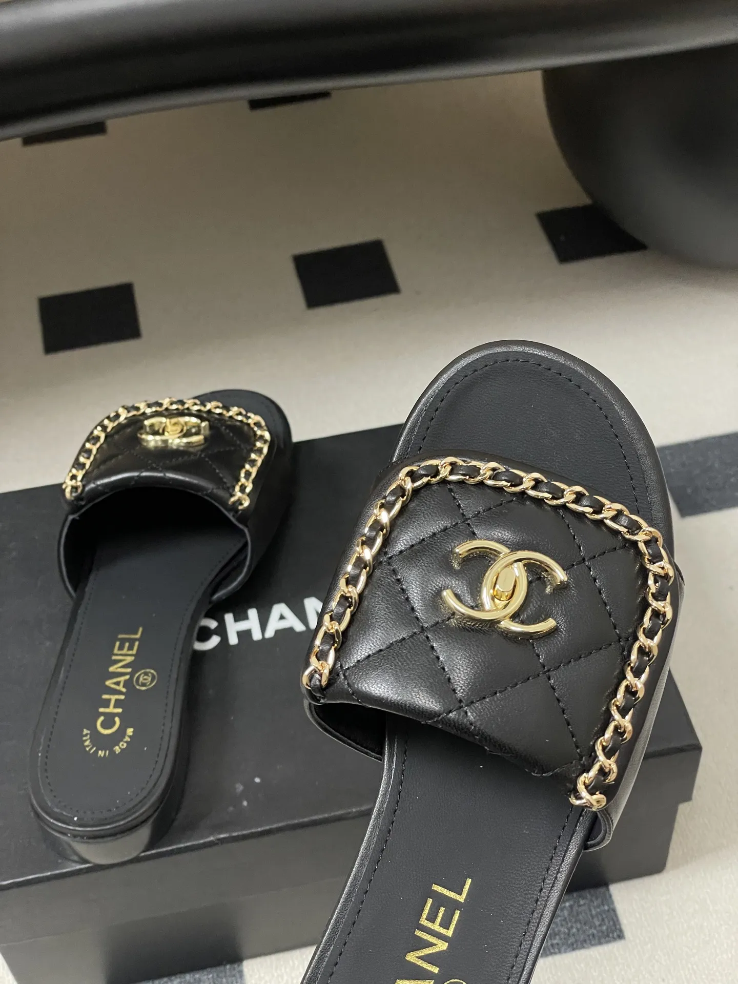 p240- 26Fw春夏新款Chanel小香经典翻盖书包扣链条一字拖鞋双C扣粗跟拖鞋 经典永不过时 简约大气，标志性翻盖双C书包扣配搭链条设计～显瘦百搭～脚感非常舒适！凸显优雅的爆品 小香粉必入！ 鞋面：羊皮/定制链条 内里垫脚：羊皮 高跟：平底/粗跟5cm 鞋底：意大利真皮大底 码数：35-39（40.41.42定做不退换）