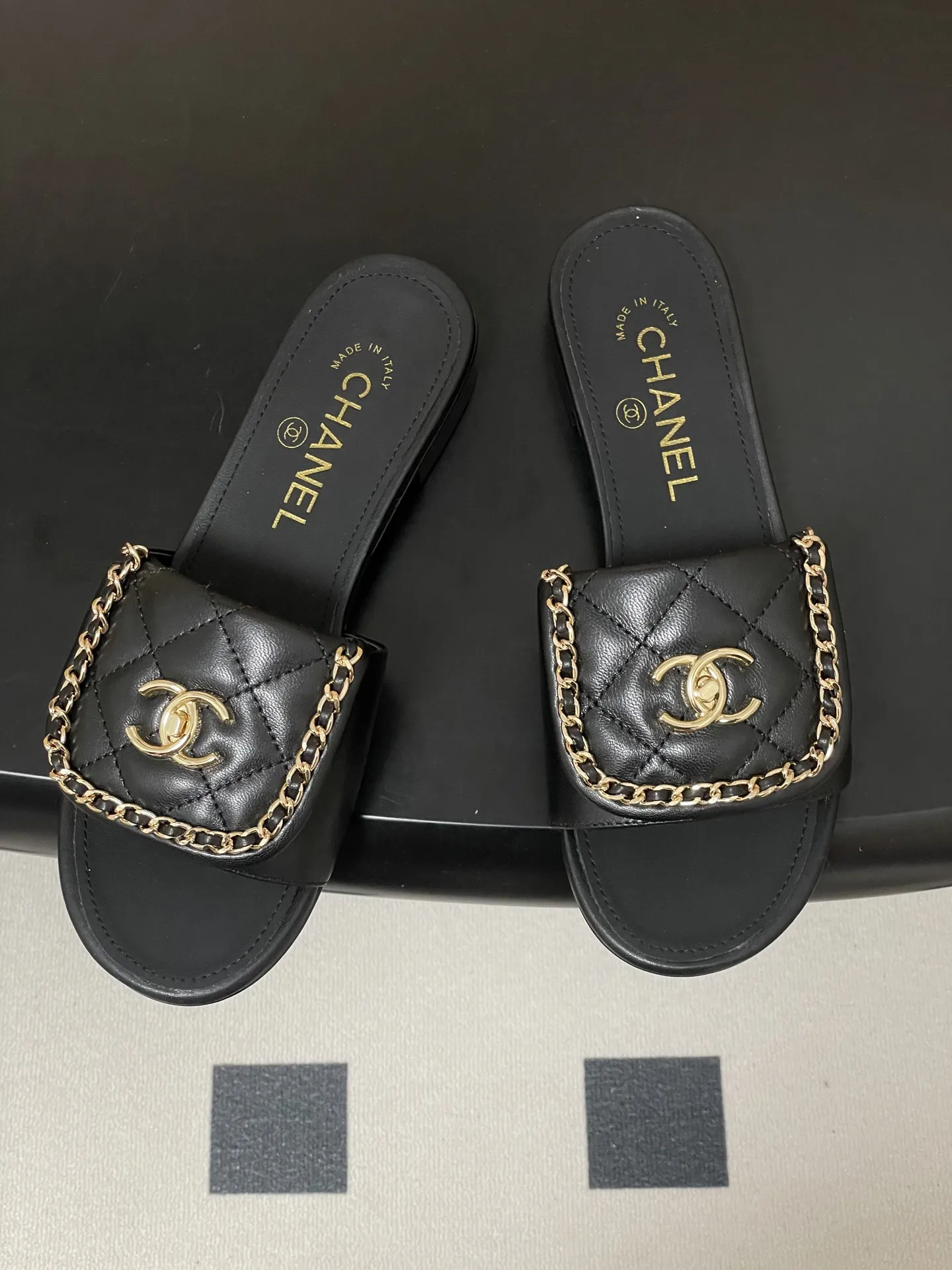 p240- 26Fw春夏新款Chanel小香经典翻盖书包扣链条一字拖鞋双C扣粗跟拖鞋 经典永不过时 简约大气,标志性翻盖双C书包扣配搭链条设计~显瘦百搭~脚感非常舒适!凸显优雅的爆品 小香粉必入! 鞋面:羊皮/定制链条 内里垫脚:羊皮 高跟:平底/粗跟5cm 鞋底:意大利真皮大底 码数:35-39(40.41.42定做不退换)