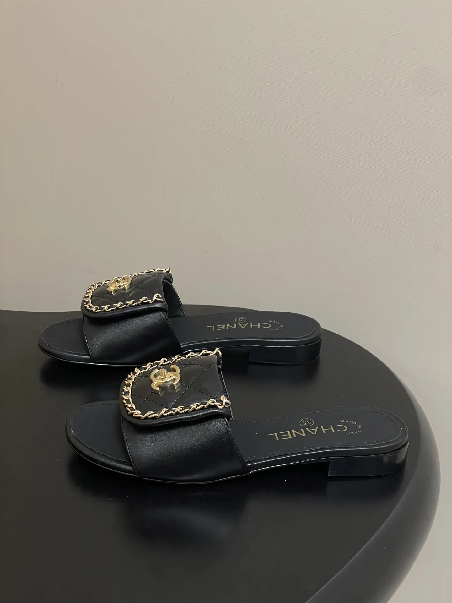 p240- 26Fw春夏新款Chanel小香经典翻盖书包扣链条一字拖鞋双C扣粗跟拖鞋 经典永不过时 简约大气，标志性翻盖双C书包扣配搭链条设计～显瘦百搭～脚感非常舒适！凸显优雅的爆品 小香粉必入！ 鞋面：羊皮/定制链条 内里垫脚：羊皮 高跟：平底/粗跟5cm 鞋底：意大利真皮大底 码数：35-39（40.41.42定做不退换）