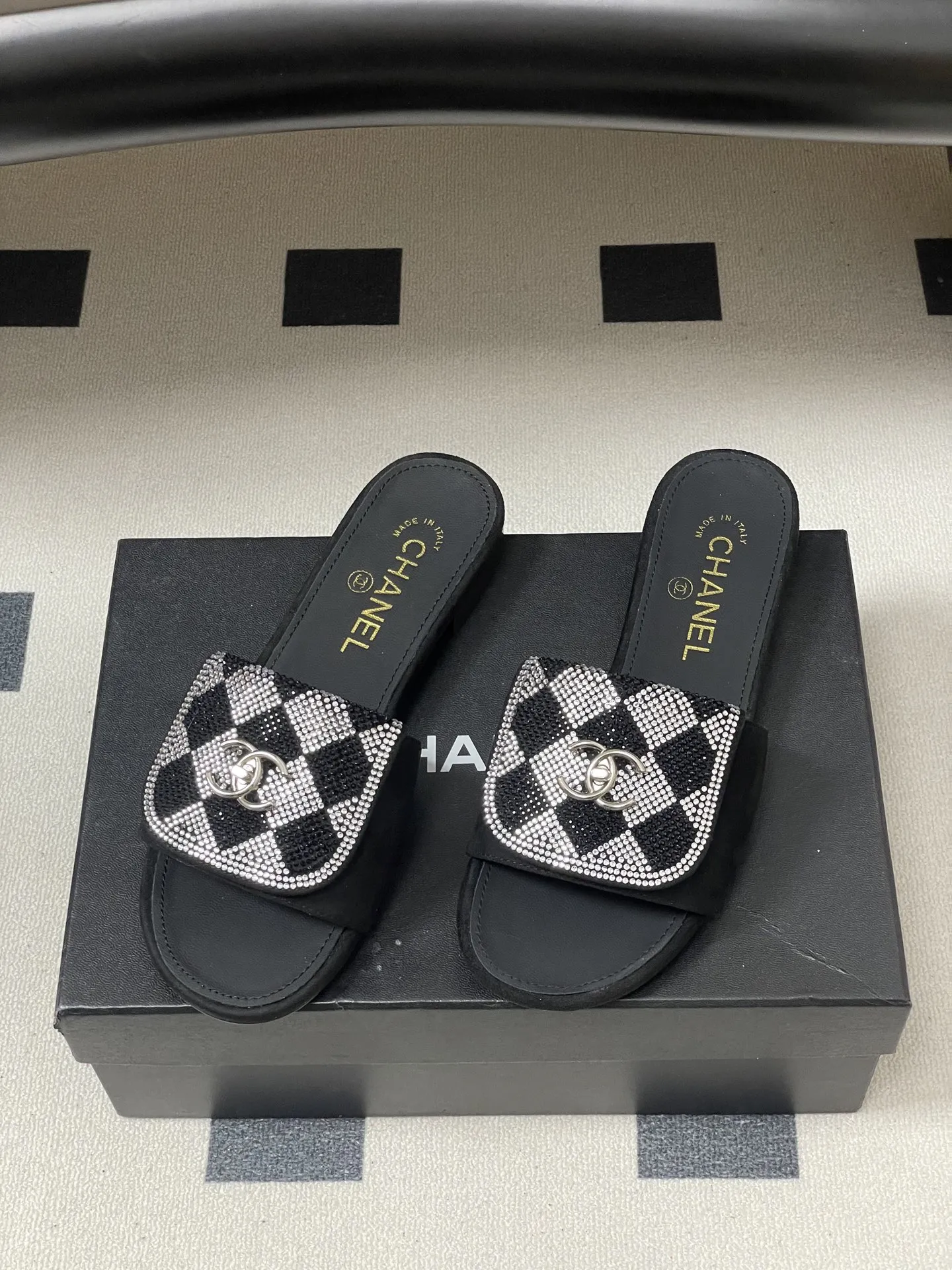 p240- 26Fw春夏新款Chanel小香经典翻盖书包扣水钻一字拖鞋新颖烫钻棋盘格粗跟拖鞋 经典永不过时 简约大气,标志性翻盖双C书包扣设计~手工镶嵌的水钻棋盘轮廓成星河,抬脚时折射出香槟色光晕,显瘦百搭~脚感非常舒适!凸显优雅的爆品 小香粉必入! 鞋面:羊猄皮/烫钻 内里垫脚:羊皮 高跟:平底/粗跟5cm 鞋底:意大利真皮大底 码数:35-39(40.41.42定做不退换)