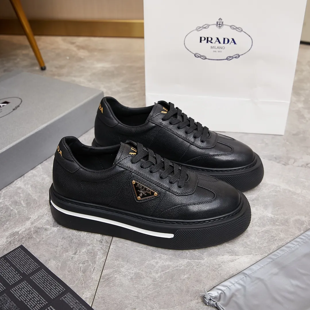 p320 普拉达 / Prada Macro Re-Nylon 系列低帮运动鞋 39-44（38.45订做） 普拉达三角标松糕运动鞋 男士 这款高帮运动鞋融Prada标志性的亮面皮革和Re-Nylon再生尼龙面料于一身，配有轻质鞋底，饰以橡胶三角形徽标，别具设计格调。 Re-Nylon再生尼龙面料通过提纯海洋塑料、渔网和纺织纤维回收物制成，为品牌的创新型面料。