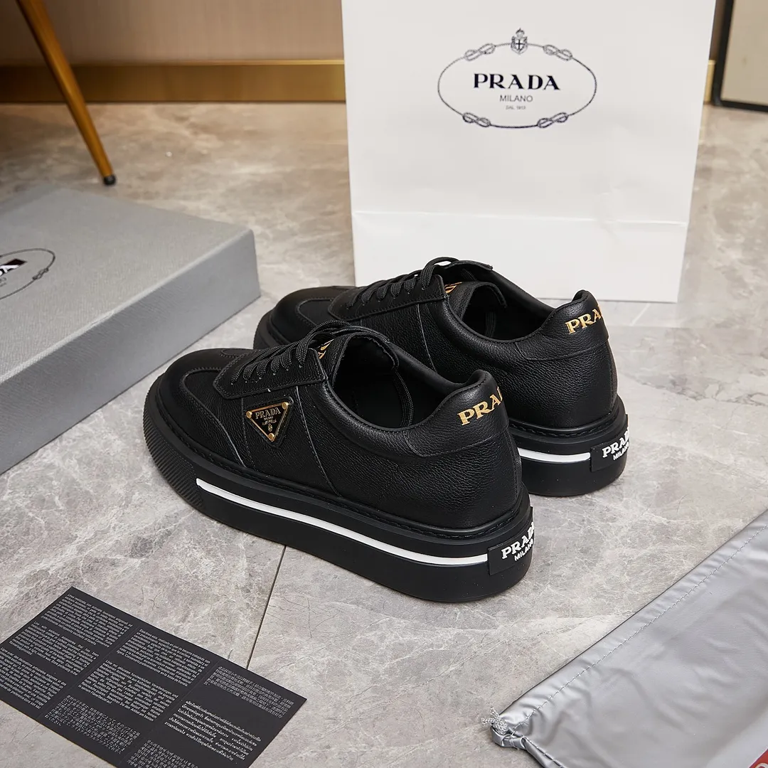 p320 普拉达 / Prada Macro Re-Nylon 系列低帮运动鞋 39-44（38.45订做） 普拉达三角标松糕运动鞋 男士 这款高帮运动鞋融Prada标志性的亮面皮革和Re-Nylon再生尼龙面料于一身，配有轻质鞋底，饰以橡胶三角形徽标，别具设计格调。 Re-Nylon再生尼龙面料通过提纯海洋塑料、渔网和纺织纤维回收物制成，为品牌的创新型面料。