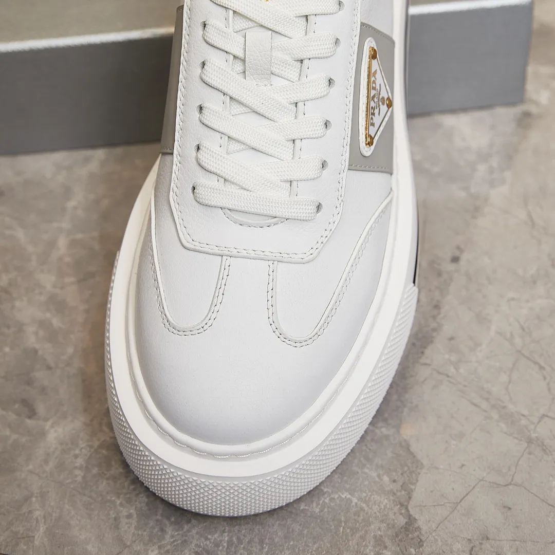 p320 普拉达 / Prada Macro Re-Nylon 系列低帮运动鞋 39-44（38.45订做） 普拉达三角标松糕运动鞋 男士 这款高帮运动鞋融Prada标志性的亮面皮革和Re-Nylon再生尼龙面料于一身，配有轻质鞋底，饰以橡胶三角形徽标，别具设计格调。 Re-Nylon再生尼龙面料通过提纯海洋塑料、渔网和纺织纤维回收物制成，为品牌的创新型面料。