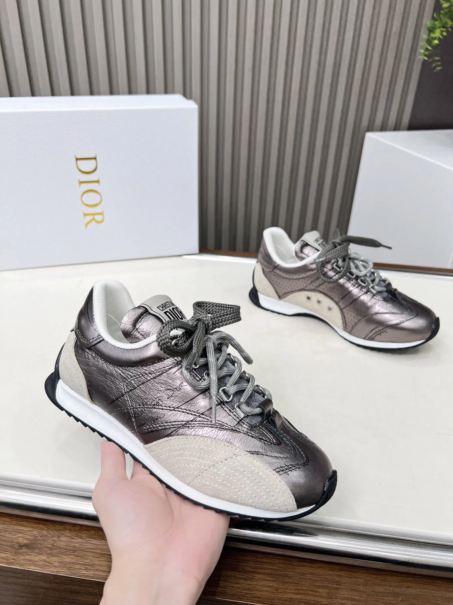 p270 这款 D-Sketch运动鞋是二零二五春夏成衣系列新品，彰显经典的复古美学。采用金色调褶皱羊皮革和金色调叠层牛皮革等材质精心制作，饰以灵感源自鞋履制作阶段的印花标志，搭配米色绒面牛皮革镶片和双鞋带。侧面饰以手写风格的Christian Dior Paris标志，鞋跟和鞋舌点缀以Christian Dior Paris 标志镶片和标牌。搭配双色纤薄橡胶鞋底更显精致，可为各式休闲造型增添高订气质。 码数：35~41（男款打板中） 颜色：黑 白 金 银