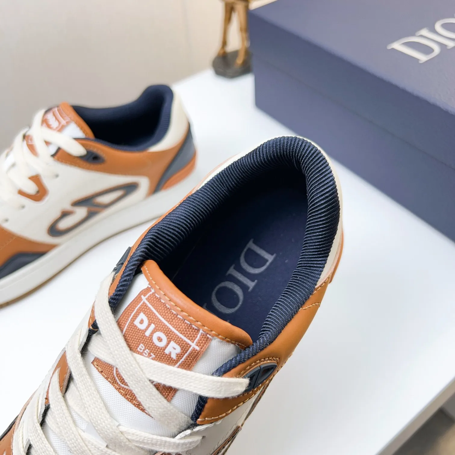 P210B57低帮运动鞋2025春季男装系列新品上市[庆祝][庆祝][庆祝]，重新诠释篮球鞋设计，成为Dior的经典单品[强][强][强]，采用黑色和奶油白色光滑牛皮精心制作，搭配米色绒面革，侧面展示皮革CD标志，鞋舌、鞋底和后侧饰以各种特色细节提升格调[666][666]，而孔眼细节、缉面线和橡胶镶片更是突显其运劲风格的动感魅力[强][强][强]，带有双色橡胶鞋底，可搭配各色服饰，打造精致造型，码数:38一45