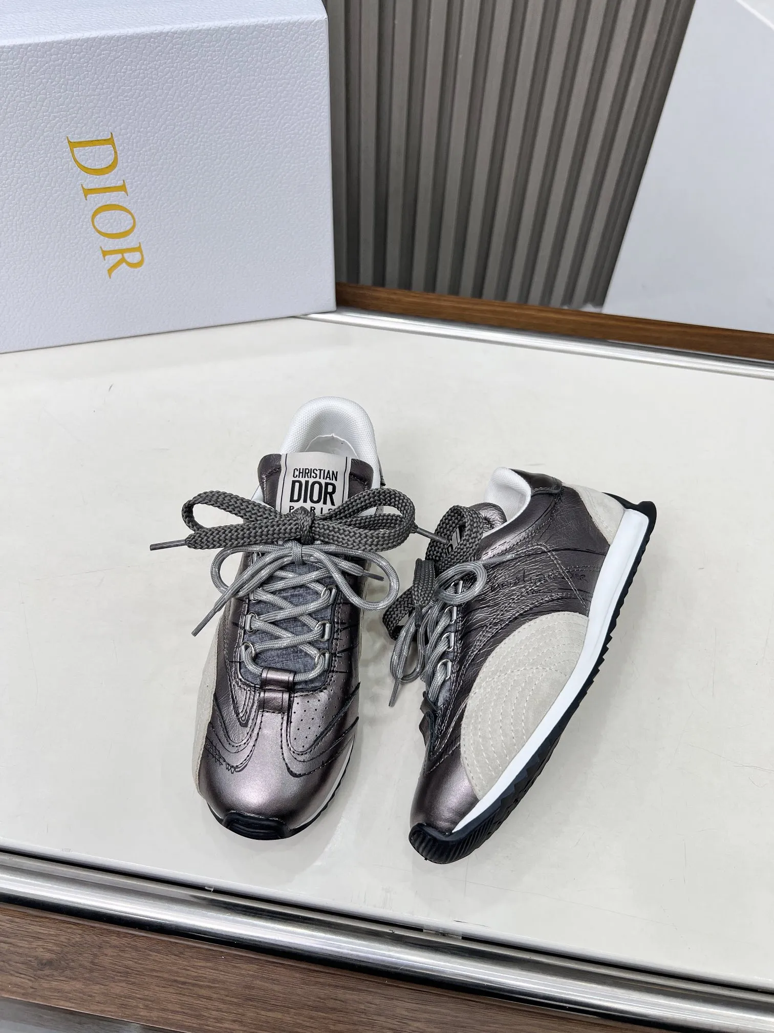 p270 这款 D-Sketch运动鞋是二零二五春夏成衣系列新品，彰显经典的复古美学。采用金色调褶皱羊皮革和金色调叠层牛皮革等材质精心制作，饰以灵感源自鞋履制作阶段的印花标志，搭配米色绒面牛皮革镶片和双鞋带。侧面饰以手写风格的Christian Dior Paris标志，鞋跟和鞋舌点缀以Christian Dior Paris 标志镶片和标牌。搭配双色纤薄橡胶鞋底更显精致，可为各式休闲造型增添高订气质。 码数：35~41（男款打板中） 颜色：黑 白 金 银