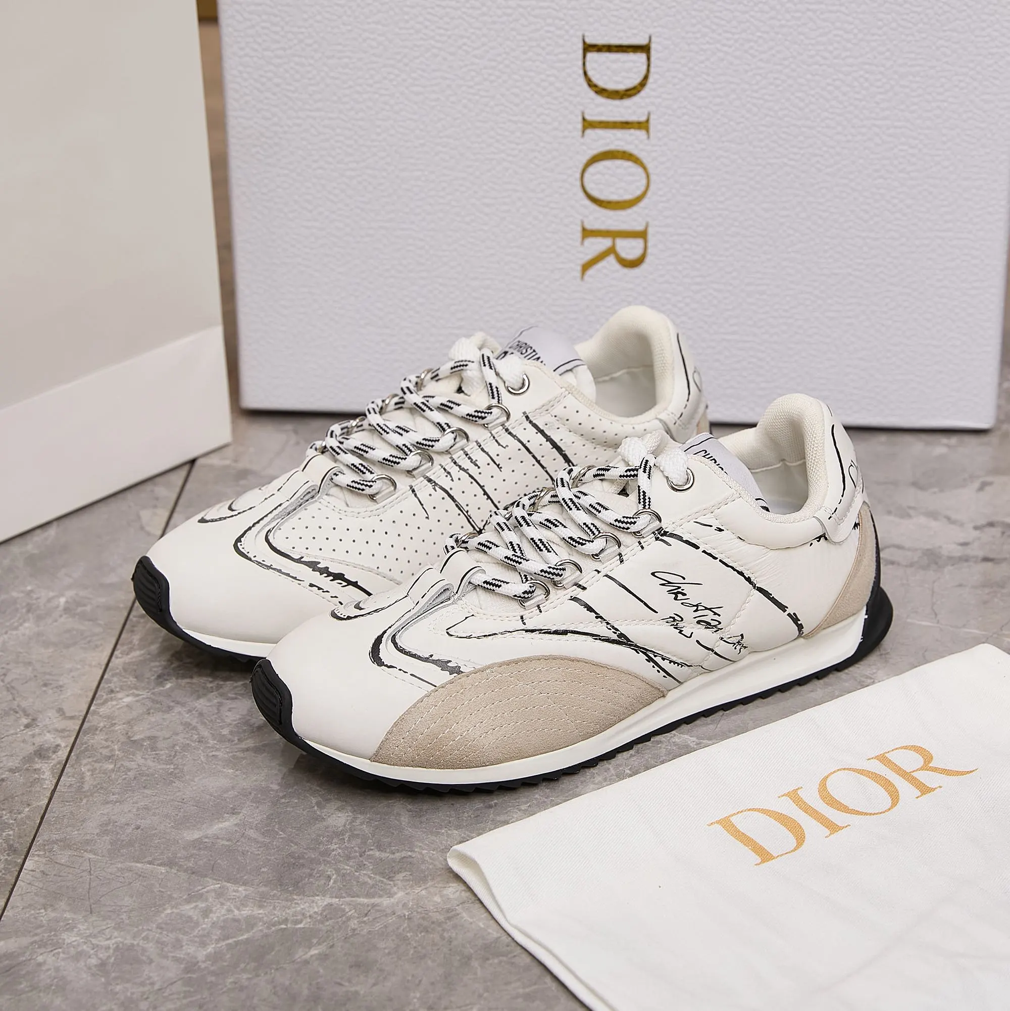 p300 迪奥 / Dior D-Sketch 运动鞋 男女35-45 白色尼龙和牛皮革 这款 D-Sketch 运动鞋于迪奥二零二五春夏成衣系列发布秀精彩亮相，彰显经典的复古美学。采用白色尼龙和牛皮革精心制作，饰以灵感源自鞋履制作阶段的印花标志，搭配米色绒面牛皮革镶片和双鞋带。侧面饰以手写风格的 Christian Dior Paris 标志，鞋跟和鞋舌点缀以 Christian Dior Paris 标志镶片和标牌。搭配双色纤薄橡胶鞋底更显精致，可为各式休闲造型增添高订气质。 帮面材质：牛皮革，牛剖层革，织物 装饰物及装饰线除外 侧面、鞋舌和鞋跟饰以 Christian Dior Paris 标志 双色纤薄橡胶鞋底饰以 Christian Dior 的幸运星符号