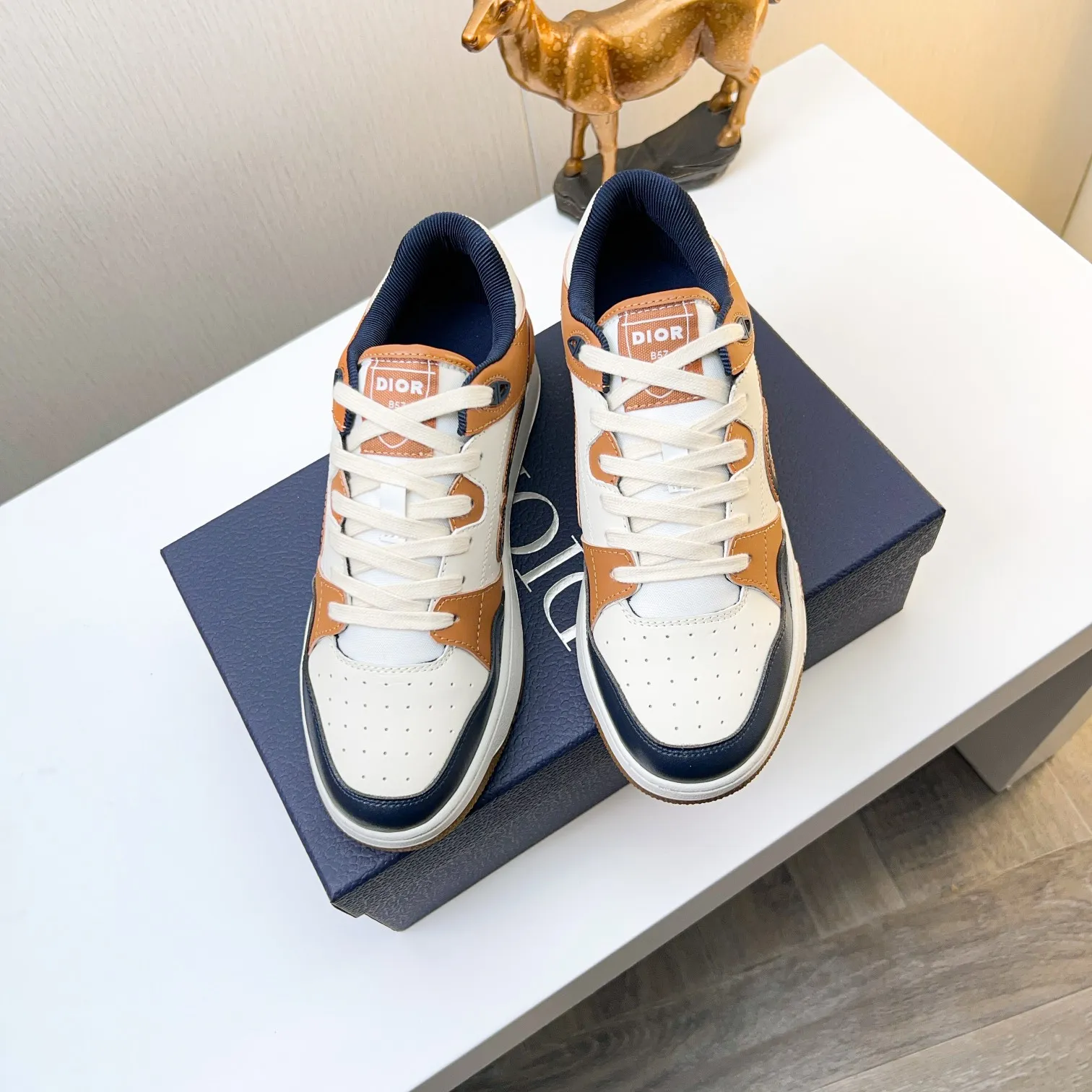 P210B57低帮运动鞋2025春季男装系列新品上市[庆祝][庆祝][庆祝]，重新诠释篮球鞋设计，成为Dior的经典单品[强][强][强]，采用黑色和奶油白色光滑牛皮精心制作，搭配米色绒面革，侧面展示皮革CD标志，鞋舌、鞋底和后侧饰以各种特色细节提升格调[666][666]，而孔眼细节、缉面线和橡胶镶片更是突显其运劲风格的动感魅力[强][强][强]，带有双色橡胶鞋底，可搭配各色服饰，打造精致造型，码数:38一45