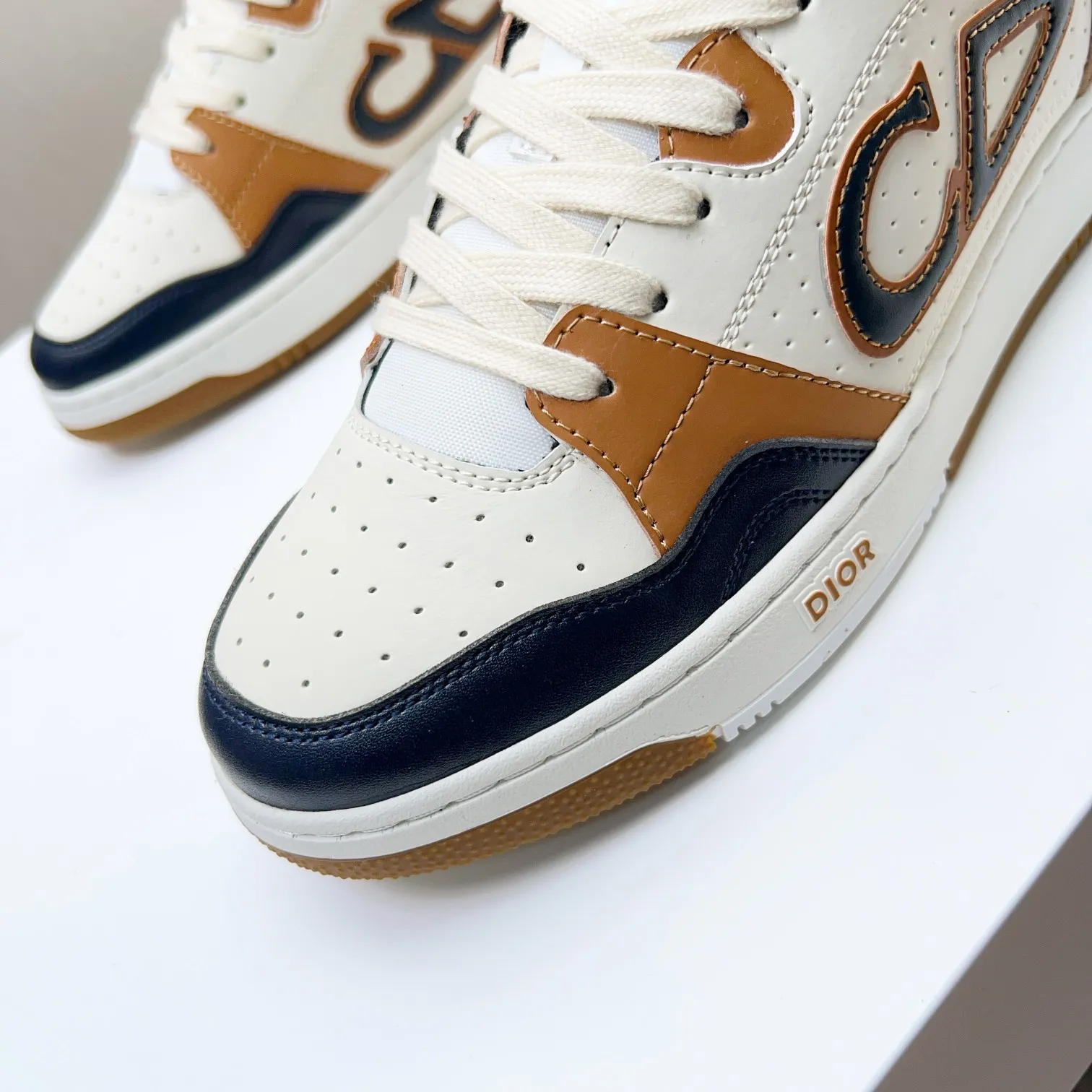 P210B57低帮运动鞋2025春季男装系列新品上市[庆祝][庆祝][庆祝]，重新诠释篮球鞋设计，成为Dior的经典单品[强][强][强]，采用黑色和奶油白色光滑牛皮精心制作，搭配米色绒面革，侧面展示皮革CD标志，鞋舌、鞋底和后侧饰以各种特色细节提升格调[666][666]，而孔眼细节、缉面线和橡胶镶片更是突显其运劲风格的动感魅力[强][强][强]，带有双色橡胶鞋底，可搭配各色服饰，打造精致造型，码数:38一45