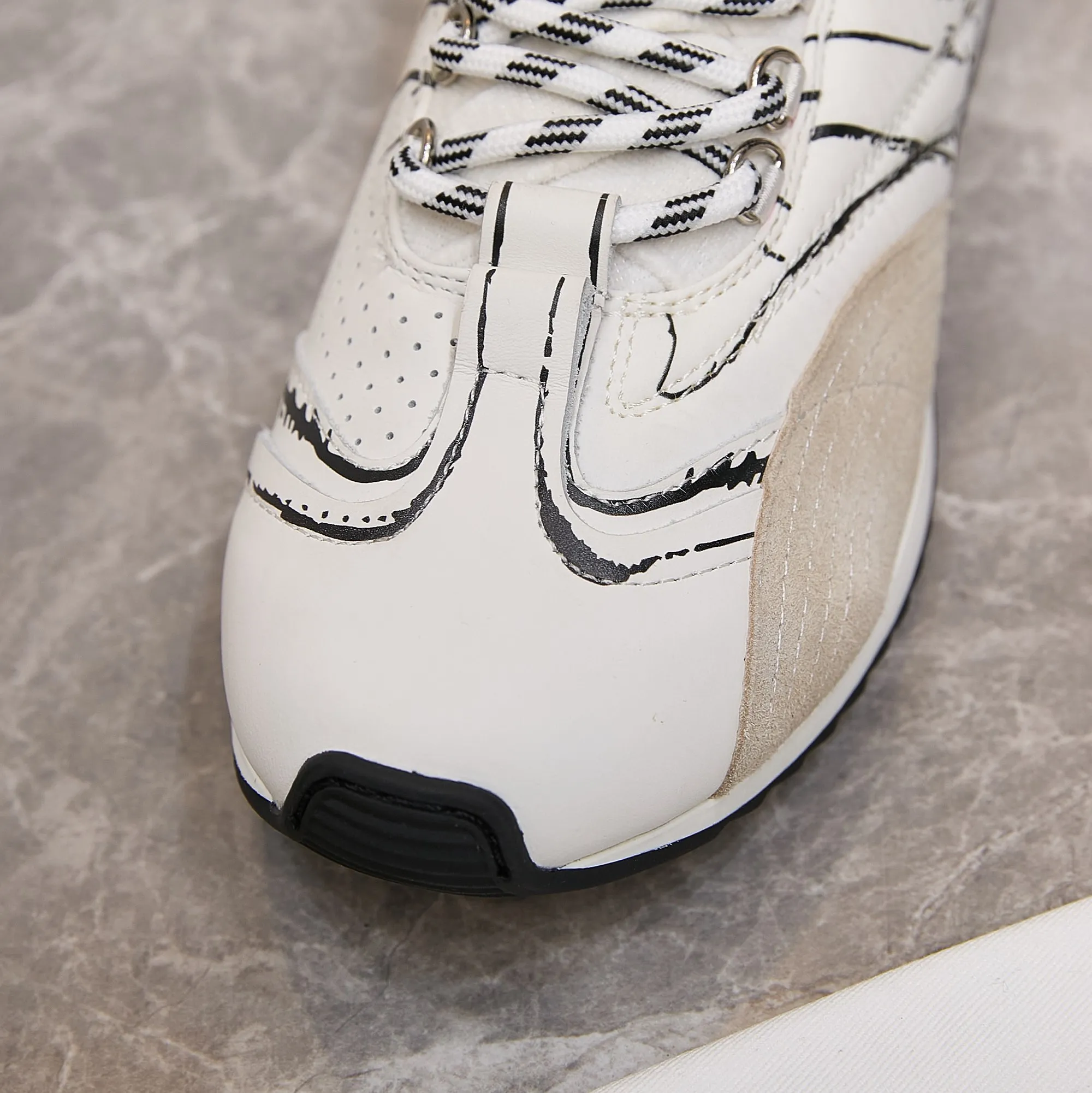 p300 迪奥 / Dior D-Sketch 运动鞋 男女35-45 白色尼龙和牛皮革 这款 D-Sketch 运动鞋于迪奥二零二五春夏成衣系列发布秀精彩亮相,彰显经典的复古美学。采用白色尼龙和牛皮革精心制作,饰以灵感源自鞋履制作阶段的印花标志,搭配米色绒面牛皮革镶片和双鞋带。侧面饰以手写风格的 Christian Dior Paris 标志,鞋跟和鞋舌点缀以 Christian Dior Paris 标志镶片和标牌。搭配双色纤薄橡胶鞋底更显精致,可为各式休闲造型增添高订气质。 帮面材质:牛皮革,牛剖层革,织物 装饰物及装饰线除外 侧面、鞋舌和鞋跟饰以 Christian Dior Paris 标志 双色纤薄橡胶鞋底饰以 Christian Dior 的幸运星符号