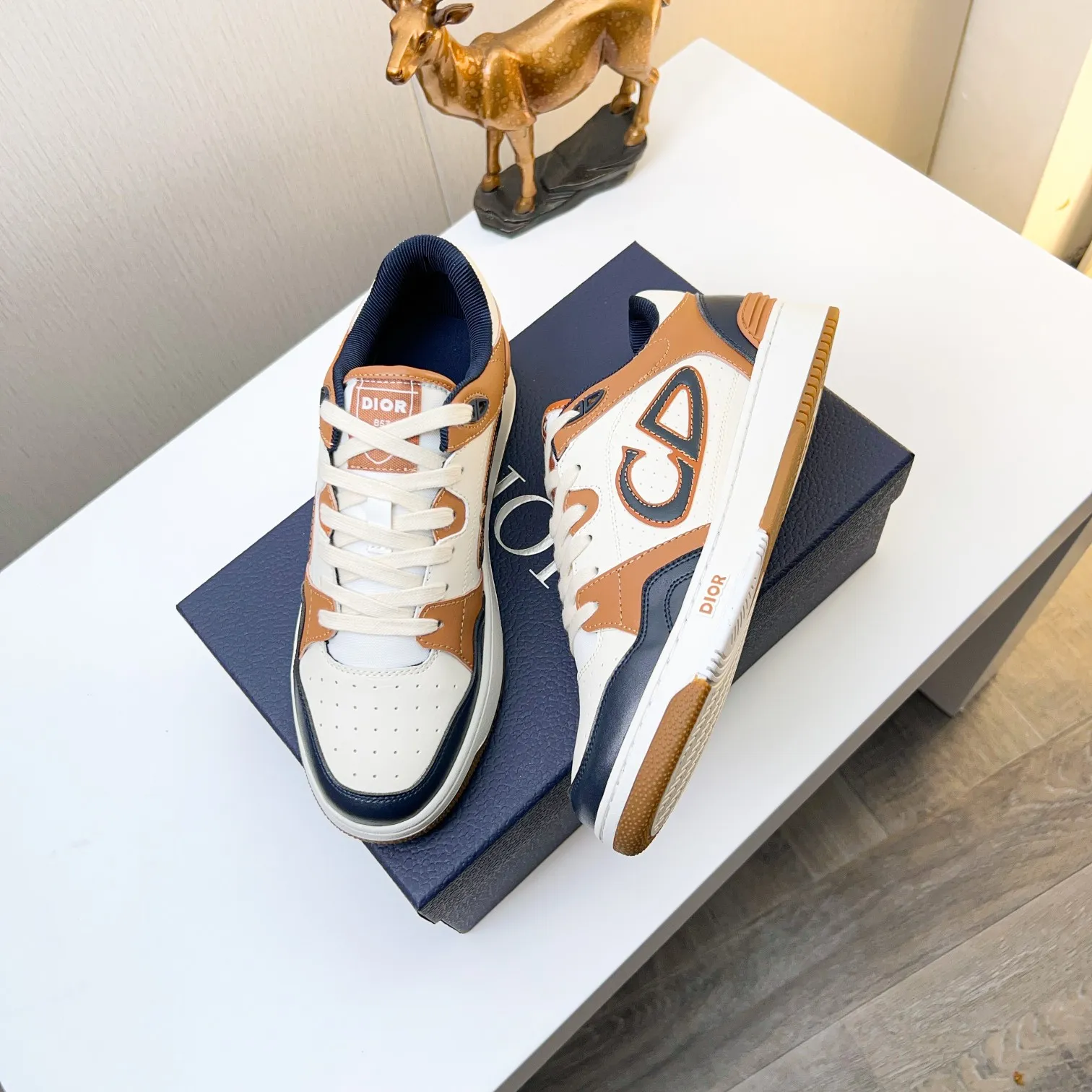 P210B57低帮运动鞋2025春季男装系列新品上市[庆祝][庆祝][庆祝]，重新诠释篮球鞋设计，成为Dior的经典单品[强][强][强]，采用黑色和奶油白色光滑牛皮精心制作，搭配米色绒面革，侧面展示皮革CD标志，鞋舌、鞋底和后侧饰以各种特色细节提升格调[666][666]，而孔眼细节、缉面线和橡胶镶片更是突显其运劲风格的动感魅力[强][强][强]，带有双色橡胶鞋底，可搭配各色服饰，打造精致造型，码数:38一45