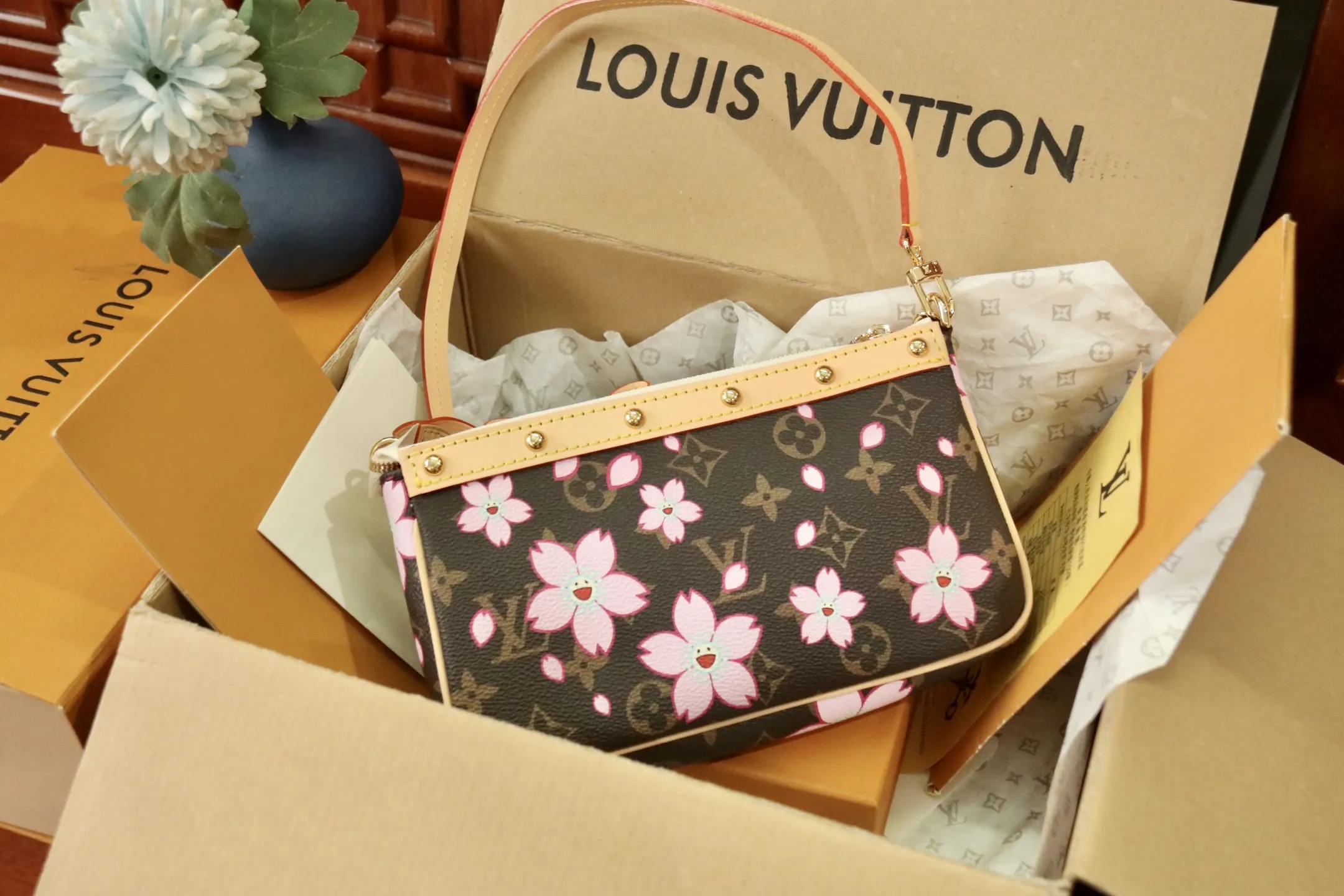 M13666樱花 🌟P350 本款 Pochette Accessoires 手袋为经典 Monogram 帆布融入村上隆笔下的明媚 Cherry Blossom 图案,以玩趣格调道出路易威登 x 村上隆复刻系列的鲜明元素。皮革蝴蝶结与 LV 铭纹挂锁点亮上缘,耀目饰钉与可拆卸链条注入一丝不羁气息。13 x 4 x 22 厘米