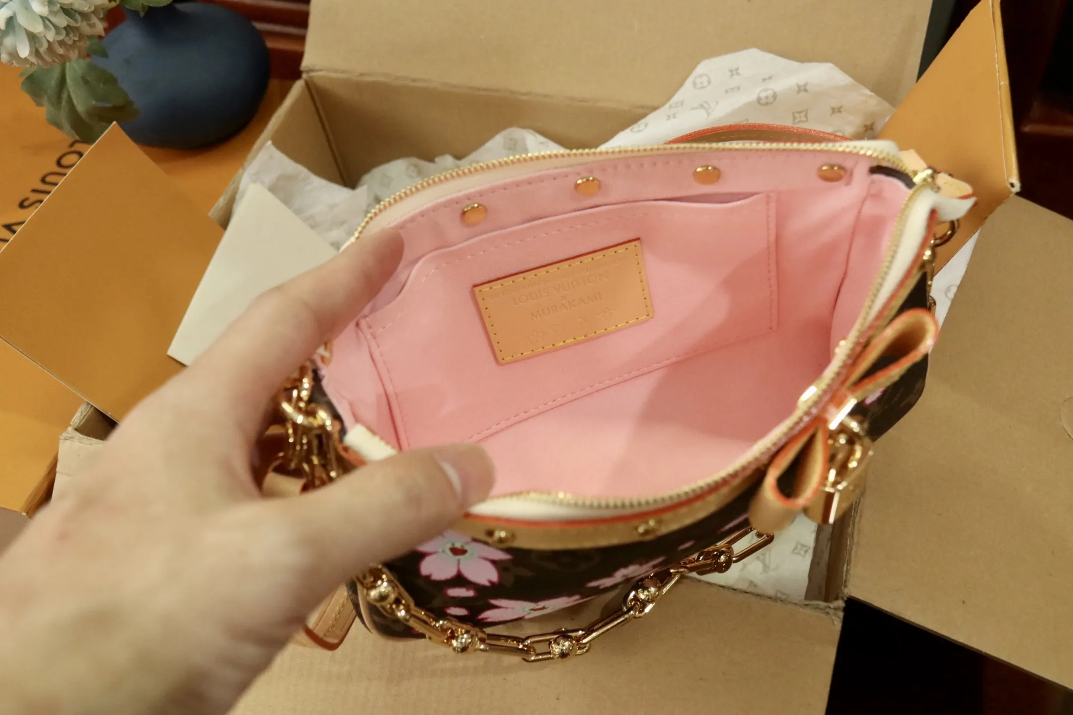 M13666樱花 🌟P350 本款 Pochette Accessoires 手袋为经典 Monogram 帆布融入村上隆笔下的明媚 Cherry Blossom 图案,以玩趣格调道出路易威登 x 村上隆复刻系列的鲜明元素。皮革蝴蝶结与 LV 铭纹挂锁点亮上缘,耀目饰钉与可拆卸链条注入一丝不羁气息。13 x 4 x 22 厘米