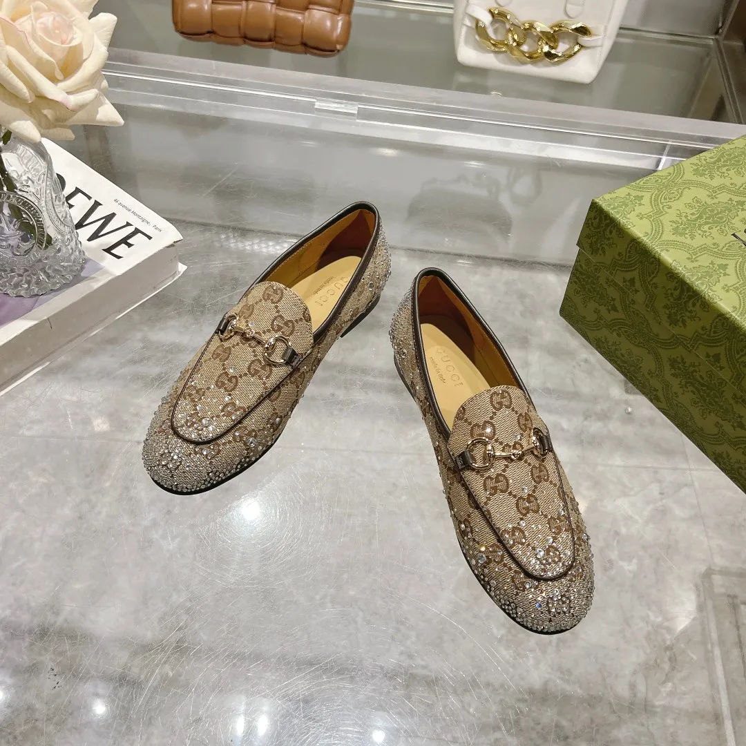 1819-1 杏G钻 ¥280(35-41)作为Gucci设计传承的杰出代表,Jordaan系列饰马衔扣乐福鞋生动彰显经典优雅格调。这款鞋履采用品牌标志性字母图案帆布,成就隽永经典。这款鞋履材质柔软,廓形精致流畅,彰显日常优雅风范。 米色和深棕色GG帆布 女士 浅金色调配件 马衔扣 多刻面水晶细节 皮革鞋底 平底