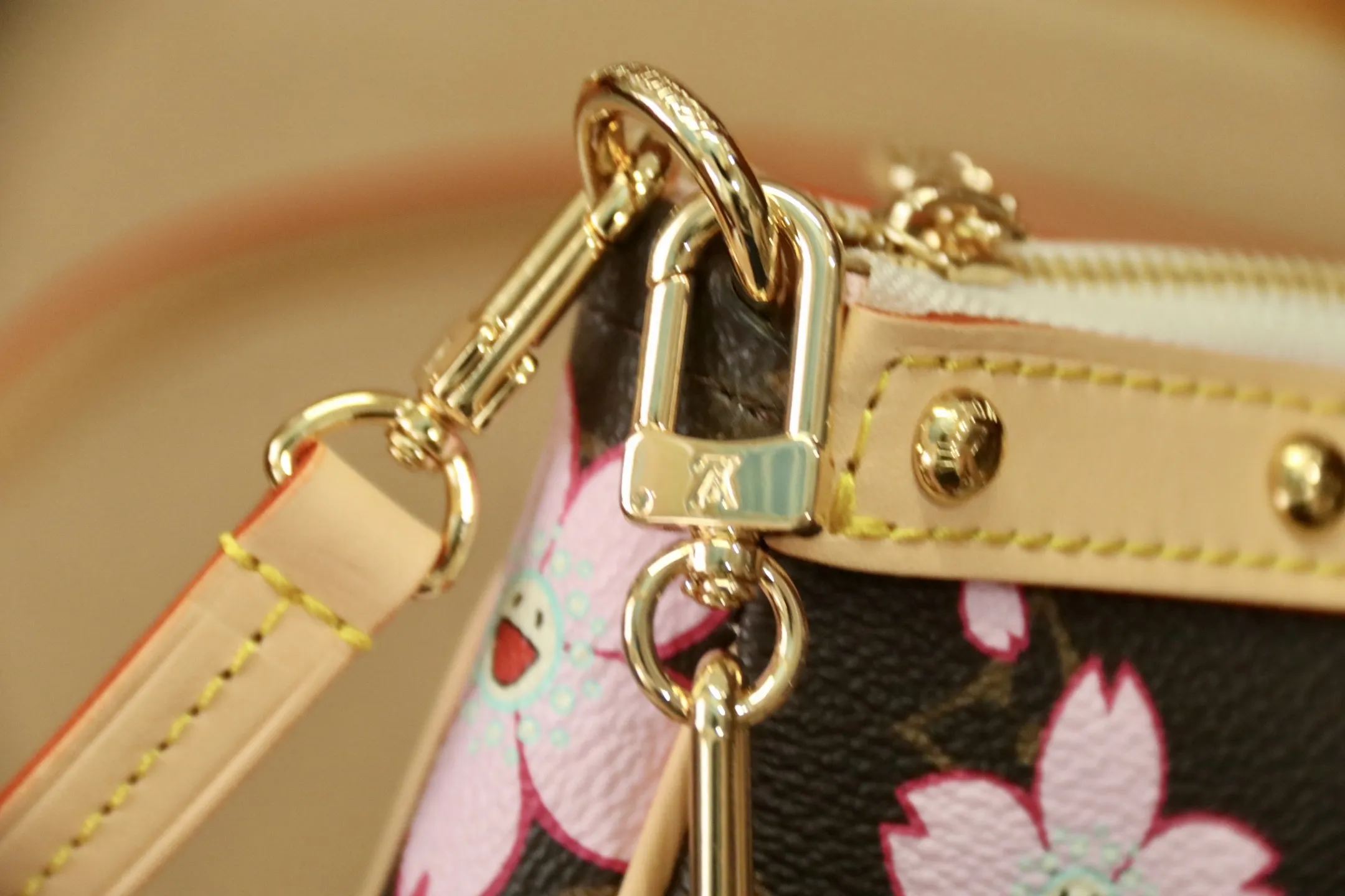 M13666樱花 🌟P350 本款 Pochette Accessoires 手袋为经典 Monogram 帆布融入村上隆笔下的明媚 Cherry Blossom 图案，以玩趣格调道出路易威登 x 村上隆复刻系列的鲜明元素。皮革蝴蝶结与 LV 铭纹挂锁点亮上缘，耀目饰钉与可拆卸链条注入一丝不羁气息。13 x 4 x 22 厘米