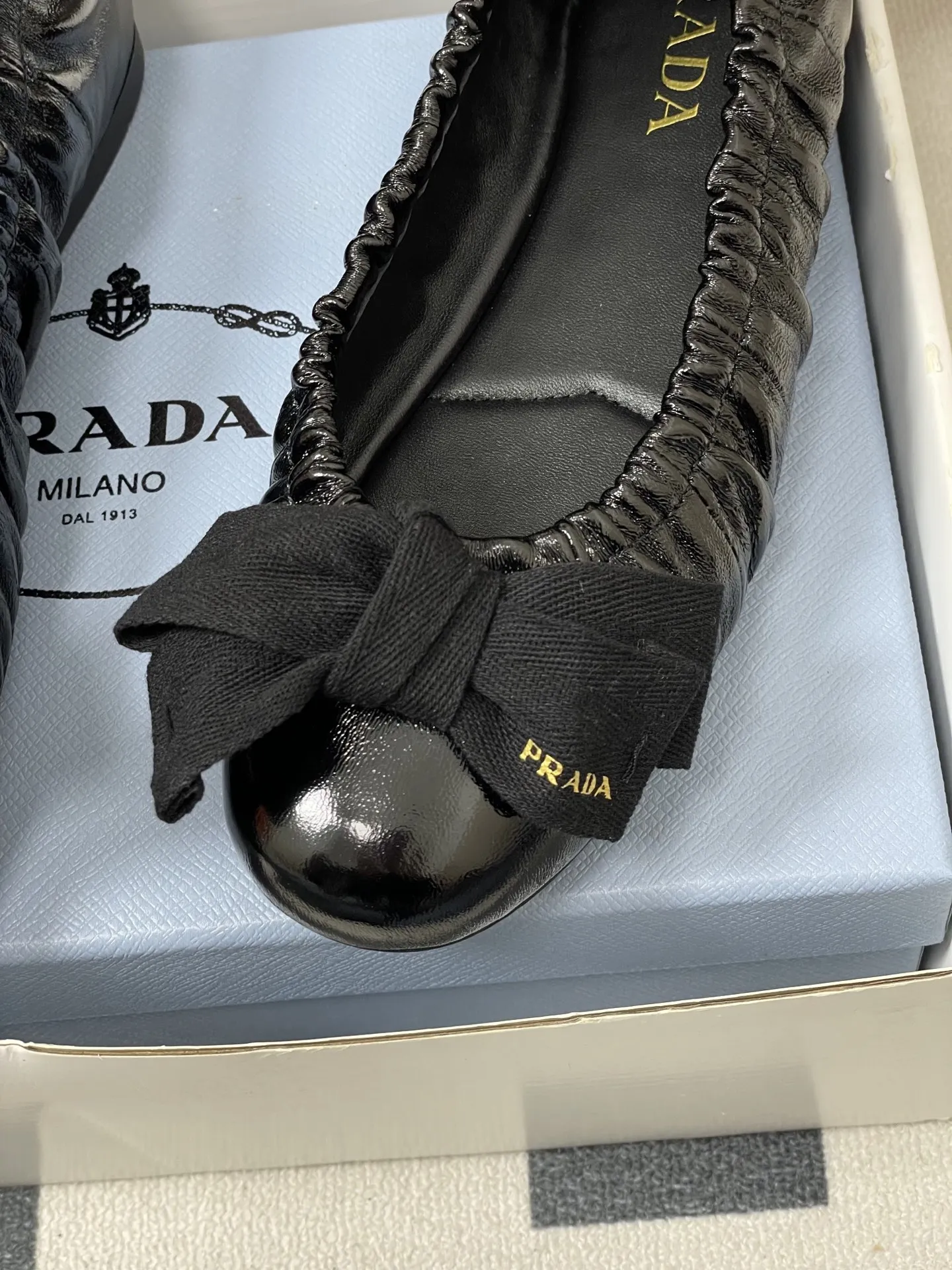 p310-顶级品质(配高档飞机盒✈️) 26Ss早春新款Prada普拉达 法式大蝴蝶结芭蕾舞鞋褶皱玛丽珍单鞋超软超舒服平底船鞋 这款蝴蝶结芭蕾舞鞋,柔软细腻,黑色蝴蝶结点缀,法式优雅复古感满满。鞋型贴合脚部,松紧口设计,穿着舒适不勒脚,适合长时间行走。金色光泽在光线下超吸睛,无论裙装还是裤装都能轻松驾驭,日常或正式场合都很出彩。鞋底轻便,兼具美观与实用,是芭蕾舞鞋爱好者的理想选择!鞋面的褶皱设计很软乎,踩上去像踩在云朵上,暴走一天也不累脚,配裤子慵懒松弛,配裙子又成了甜系公主,一鞋多搭太香了~ 5毫米一体式鞋底,饰有热压徽标 鞋面:定制羊皮/羊猄皮/马毛/皱羊漆皮 内里垫脚:羊皮 鞋底:原版开模橡胶大底 码数:35-39(40.41定做不退换)