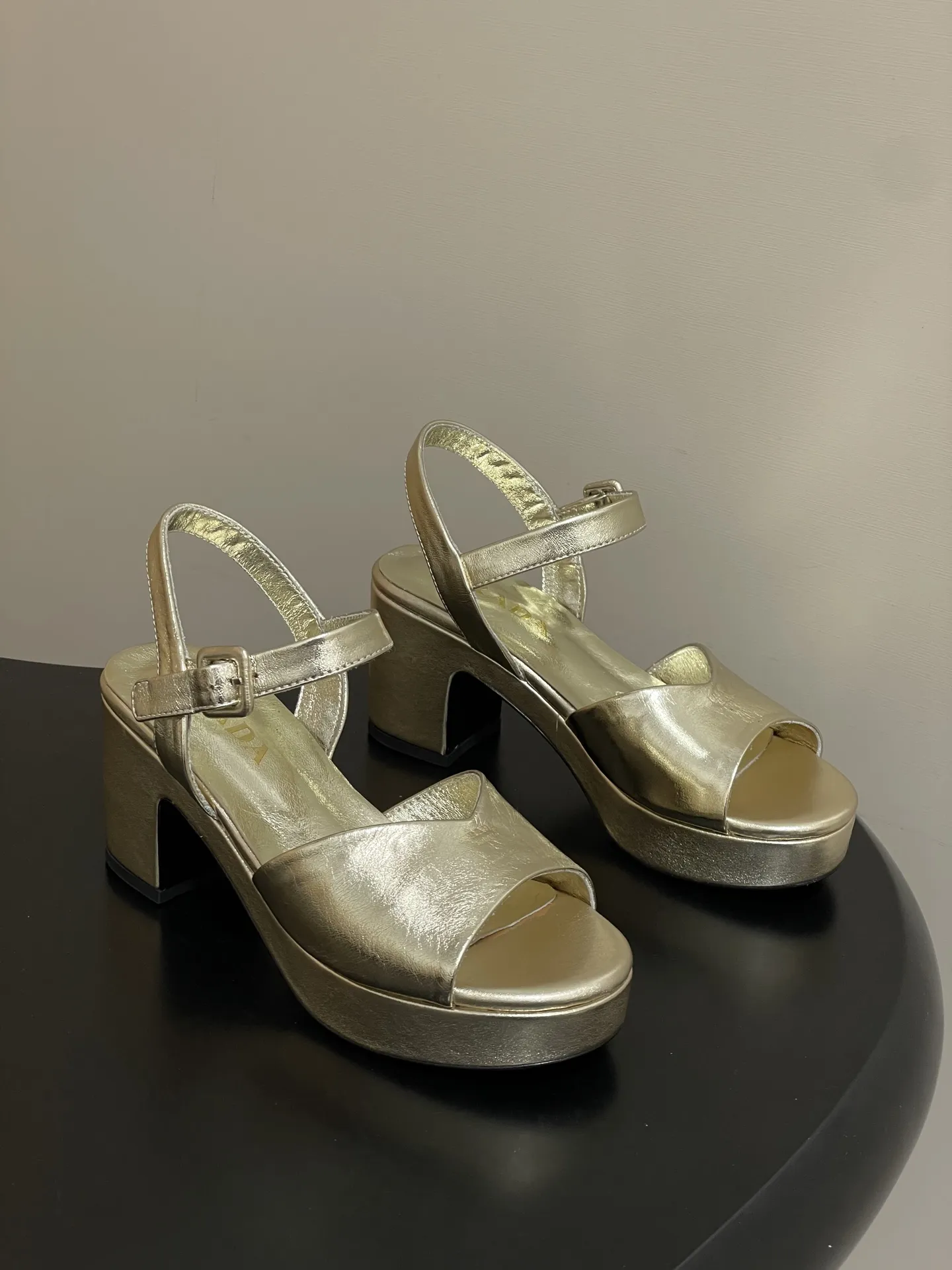 p310-顶级品质 26Aw春夏新款Prada 普拉达走秀款 鱼嘴露趾防水台高跟鞋复古老钱风露跟凉鞋 以90年代的复古凉鞋为灵感,鞋面采用交叉带设计,线条流畅利落,既修饰脚型又自带优雅氛围,是打造“老钱风”的核心单品。 露跟设计在保留优雅感的同时增添了轻盈与透气感,适配春夏季节或室内场合,也让复古鞋型更具实穿性。采用粗跟设计,在保证优雅感的同时提升了行走稳定性,解决了“好看的鞋不好走”的痛点。 鞋面:定制羊猄皮/贴膜羊皮 内里垫脚:羊皮 鞋底:意大利注塑真皮大底 跟高:8cm 码数:35-39(40.41.42定做不退换)