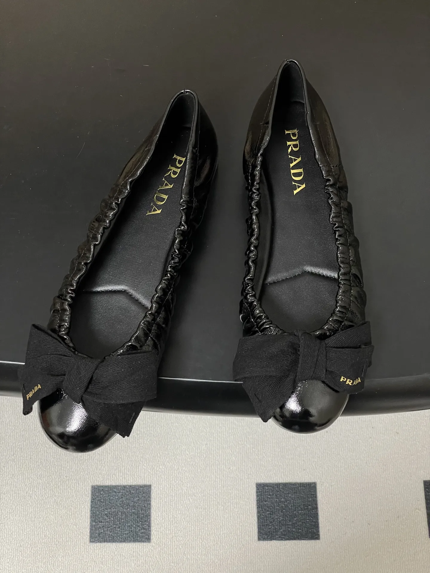 p310-顶级品质（配高档飞机盒✈️） 26Ss早春新款Prada普拉达 法式大蝴蝶结芭蕾舞鞋褶皱玛丽珍单鞋超软超舒服平底船鞋 这款蝴蝶结芭蕾舞鞋，柔软细腻，黑色蝴蝶结点缀，法式优雅复古感满满。鞋型贴合脚部，松紧口设计，穿着舒适不勒脚，适合长时间行走。金色光泽在光线下超吸睛，无论裙装还是裤装都能轻松驾驭，日常或正式场合都很出彩。鞋底轻便，兼具美观与实用，是芭蕾舞鞋爱好者的理想选择！鞋面的褶皱设计很软乎，踩上去像踩在云朵上，暴走一天也不累脚，配裤子慵懒松弛，配裙子又成了甜系公主，一鞋多搭太香了～ 5毫米一体式鞋底，饰有热压徽标 鞋面：定制羊皮/羊猄皮/马毛/皱羊漆皮 内里垫脚：羊皮 鞋底：原版开模橡胶大底 码数：35-39（40.41定做不退换）