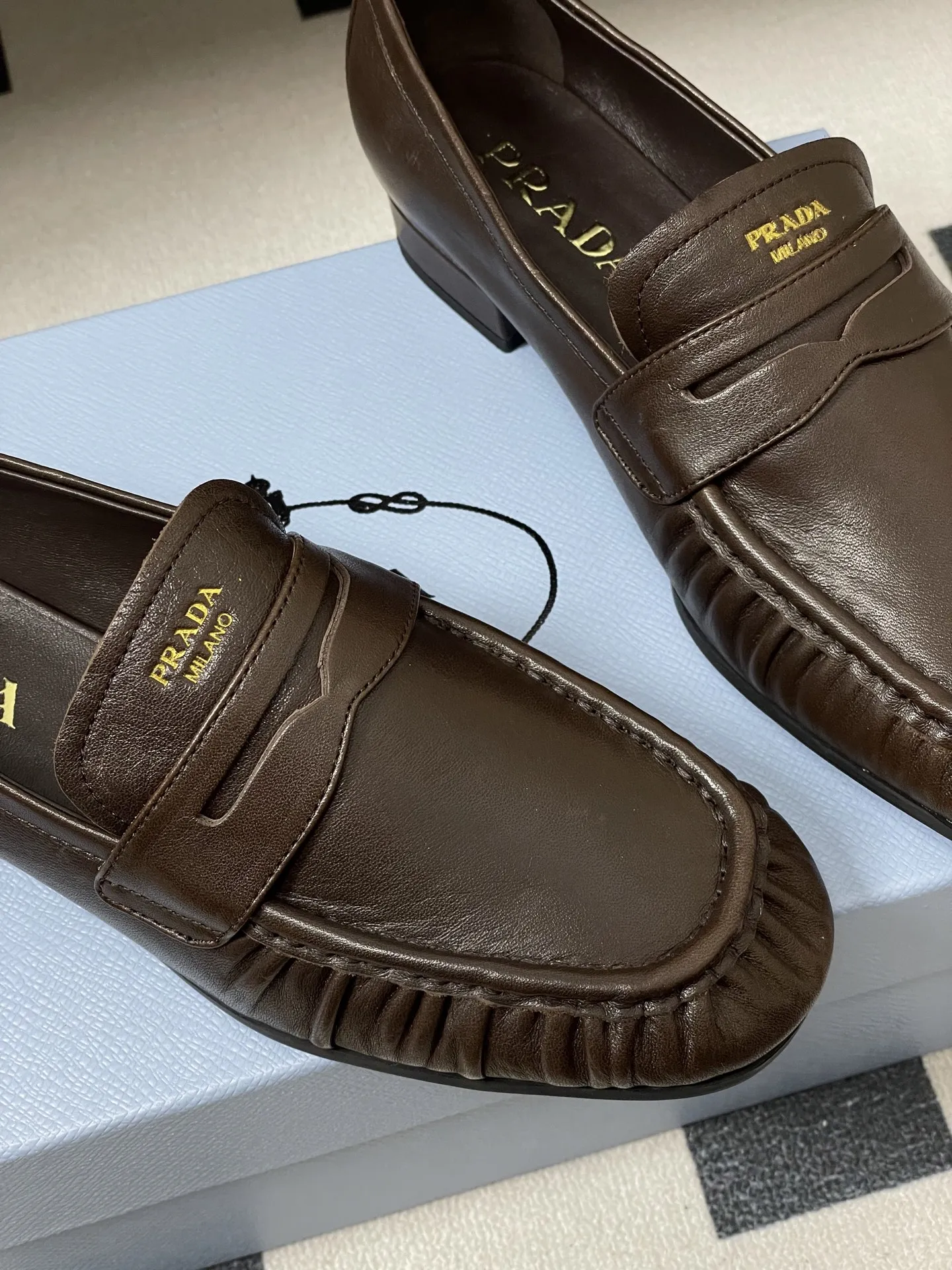 p310- 26Fw早春新款 Prada普拉达 褶皱一脚蹬乐福鞋老钱风麂皮单鞋 这款褶饰乐福鞋，选用优质皮革，柔软又耐用，鞋面褶皱设计超有辨识度!经典圆头+平底，日常通勤，休闲都能轻松驾驭。内衬和鞋垫都有PRADA标志，细节满分，低调又高级。百搭属性，无论牛仔裤还是裙装都能轻松hold住，是实用与时尚兼具的必备单品! 鞋面：油蜡小牛皮/高丝光牛反绒 内里垫脚：羊皮 鞋底：开模橡胶大底 码数：35-39（40.41定做不退换）